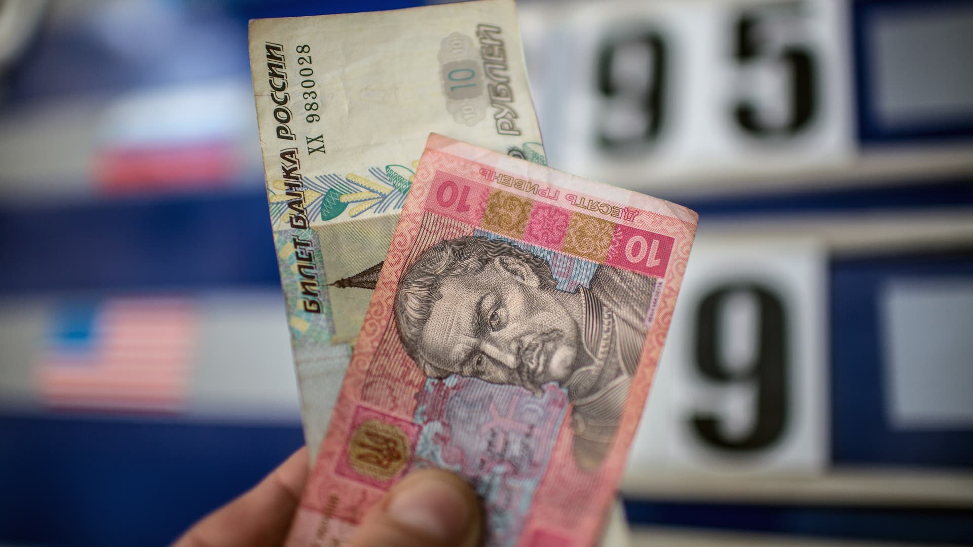 A man holds up Russian ruble and Ukrainian hryvnia notes on 18 March 2014.