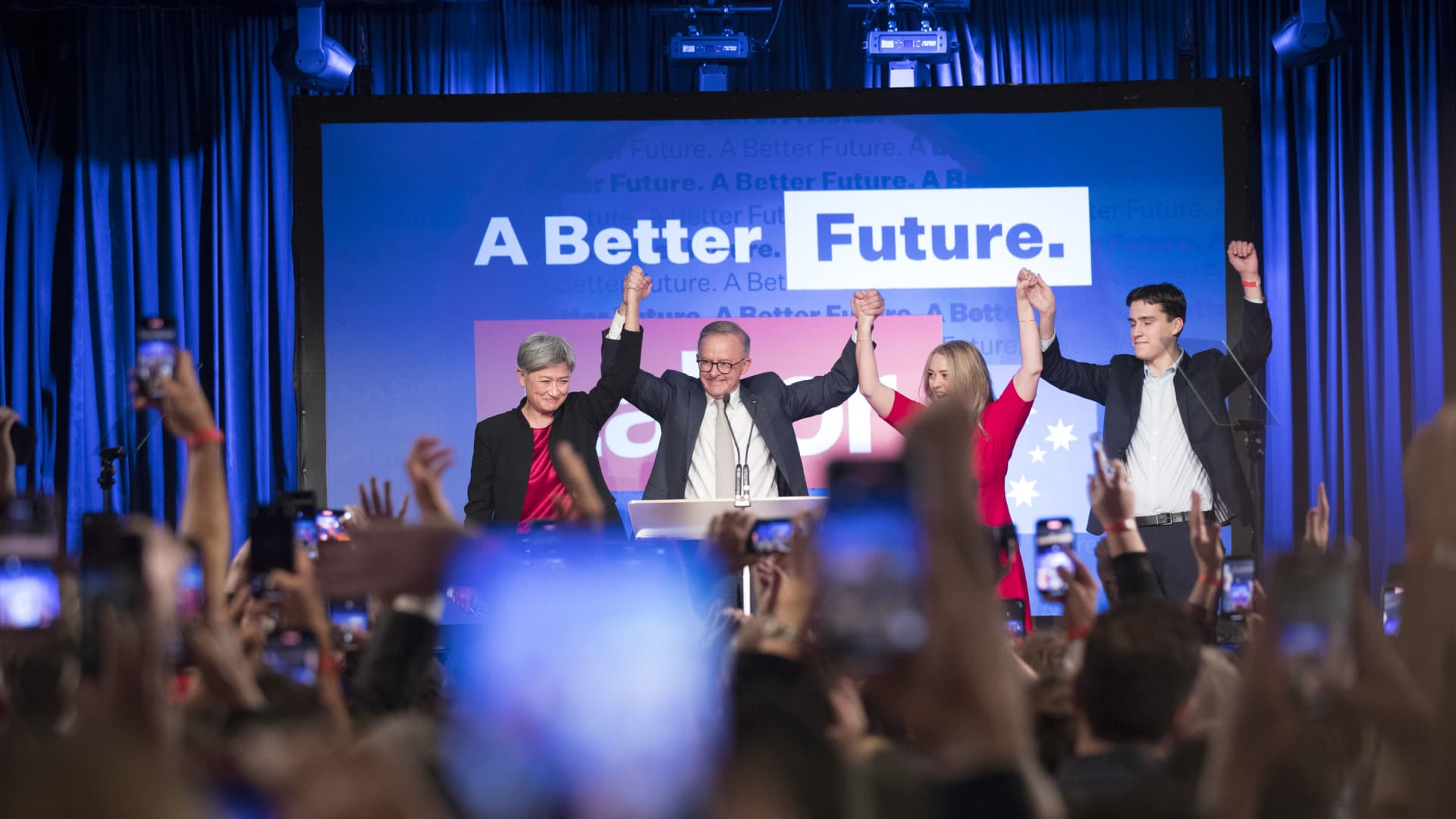 Anthony Albanese, leader of the Labor Party, stands on stage with his partner Jodie Haydon, his son Nathan Albanese, and Penny Wong, Australia's shadow foreign minister, during the party's election night event in Australia, on May 21, 2022. Businesses in Australia and their investors globally will remain wary of how the new Australian Labor government rolls out its climate change policies amid concerns it will come under pressure to strike a new deal to stretch its emissions reduction targets, analysts say.