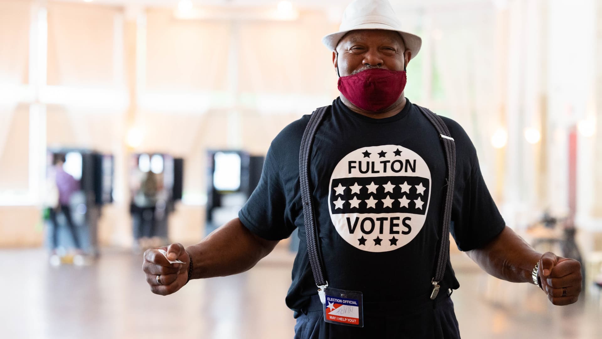 Poll worker Kelvin Ellis greets voters as they enter the Park Tavern polling location to cast their ballots in the Georgia primary election on May 24, 2022 in Atlanta, Georgia.