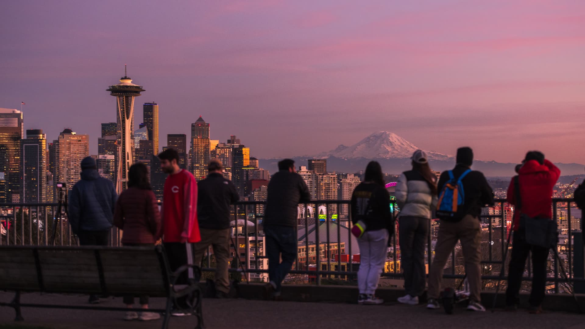 Tourists take in a sunset over the Seattle, WA skyline.
