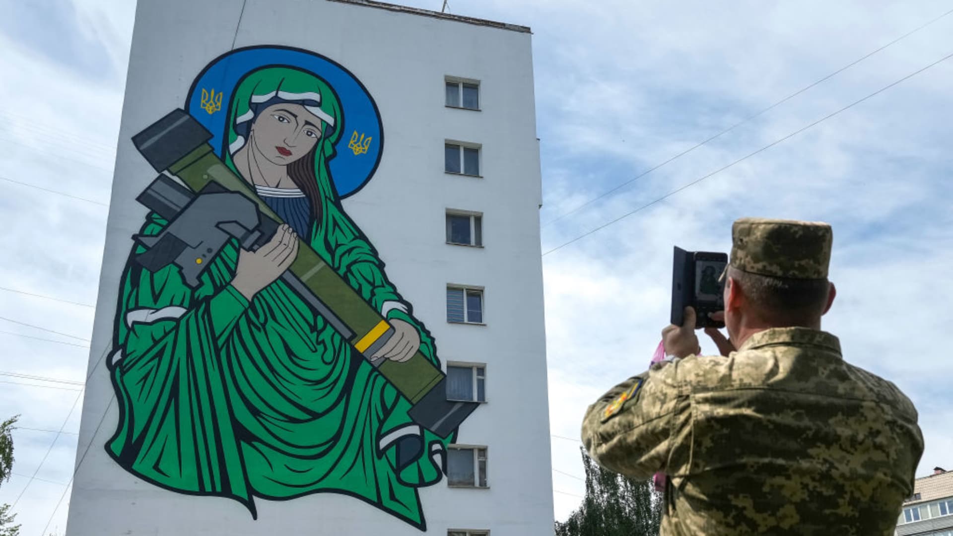 Ukrainian soldiers take pictures of a mural titled 'Saint Javelin' dedicated to the U.S.-made portable surface-to-air missile has been unveiled on the side of a Kyiv apartment block on May 25, 2022 in Kyiv, Ukraine. The artwork by illustrator and artist Chris Shaw is in reference to the Javelin missile donated to Ukrainian troops to battle against the Russian invasion.