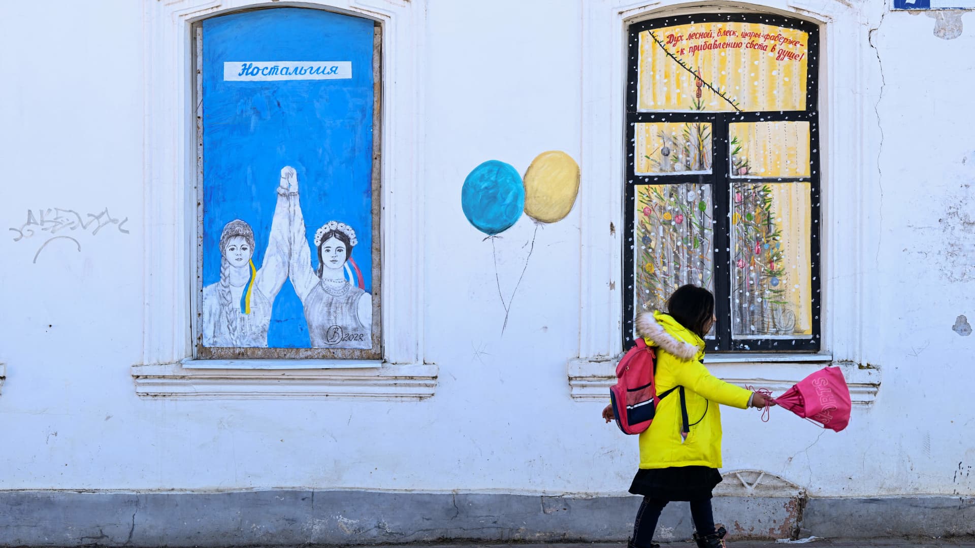 A child walks past by a graffiti made by the artist Vladimir Ovchinnikov in Borovsk, some 100kms south-west of Moscow, on April 14, 2022. Retired engineer Vladimir Ovchinnikov has spent decades painting murals on buildings in and around his small town south of Moscow. But since the outbreak of Russia's conflict with Ukraine, the 84-year-old has found that some of his art is not welcome.