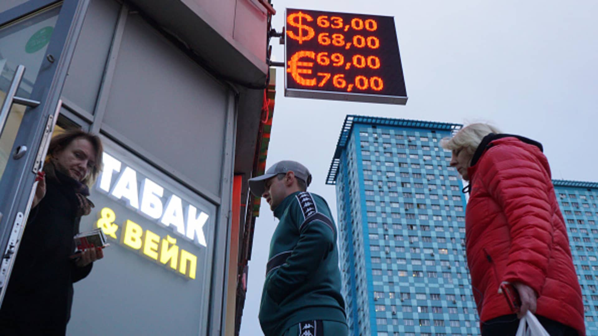 People line up near Euro and U.S. dollars rates to ruble sign board at the entrance to the exchange office on May 25, 2022 in Moscow, Russia. Russia moved closer to a default on Wednesday after the U.S. Treasury let a key sanctions exemption expire.
