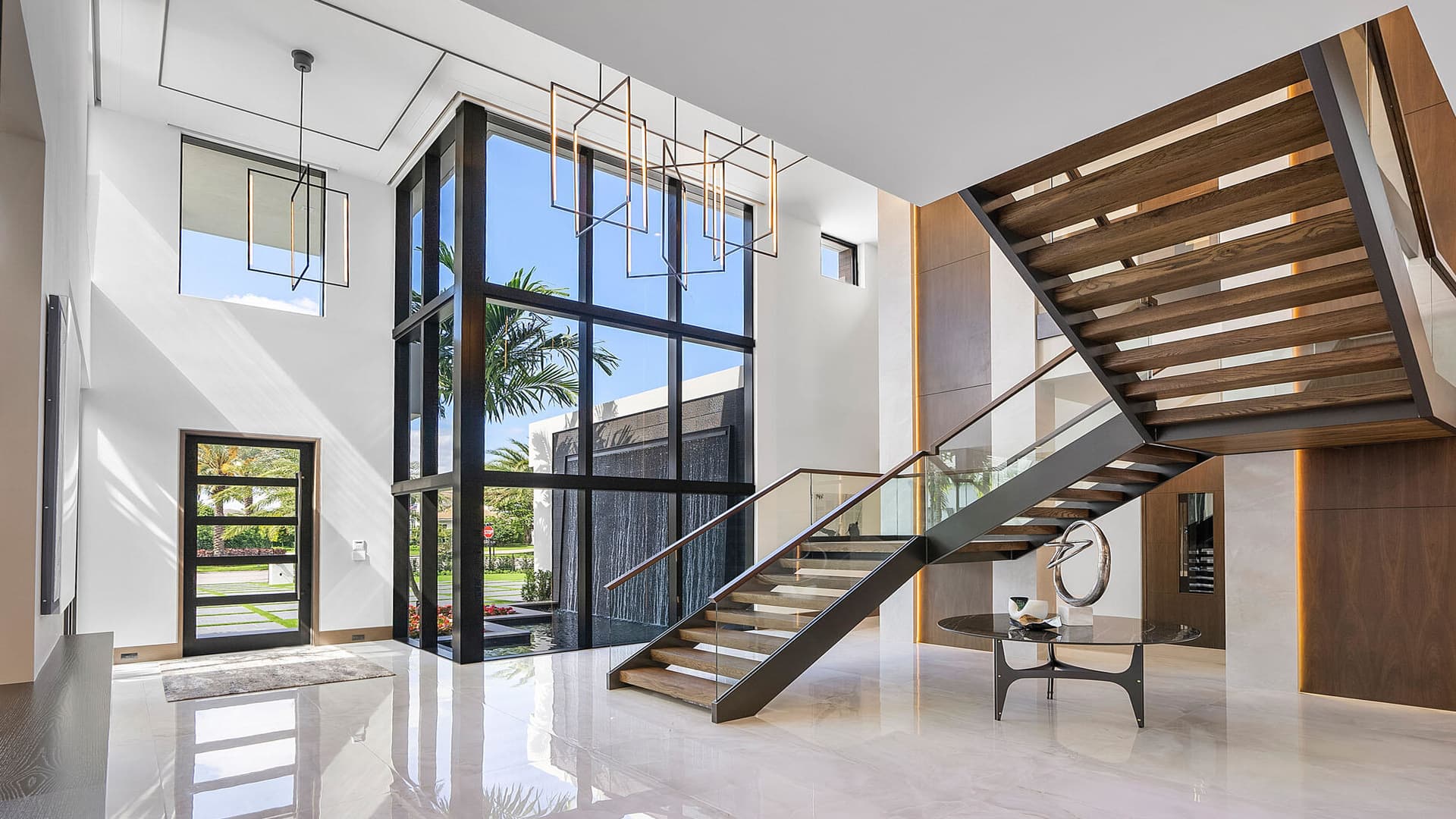 The modern interiors at 298 W Key Palm include a mix of stone & wood finishes with a dramatic floating staircase.