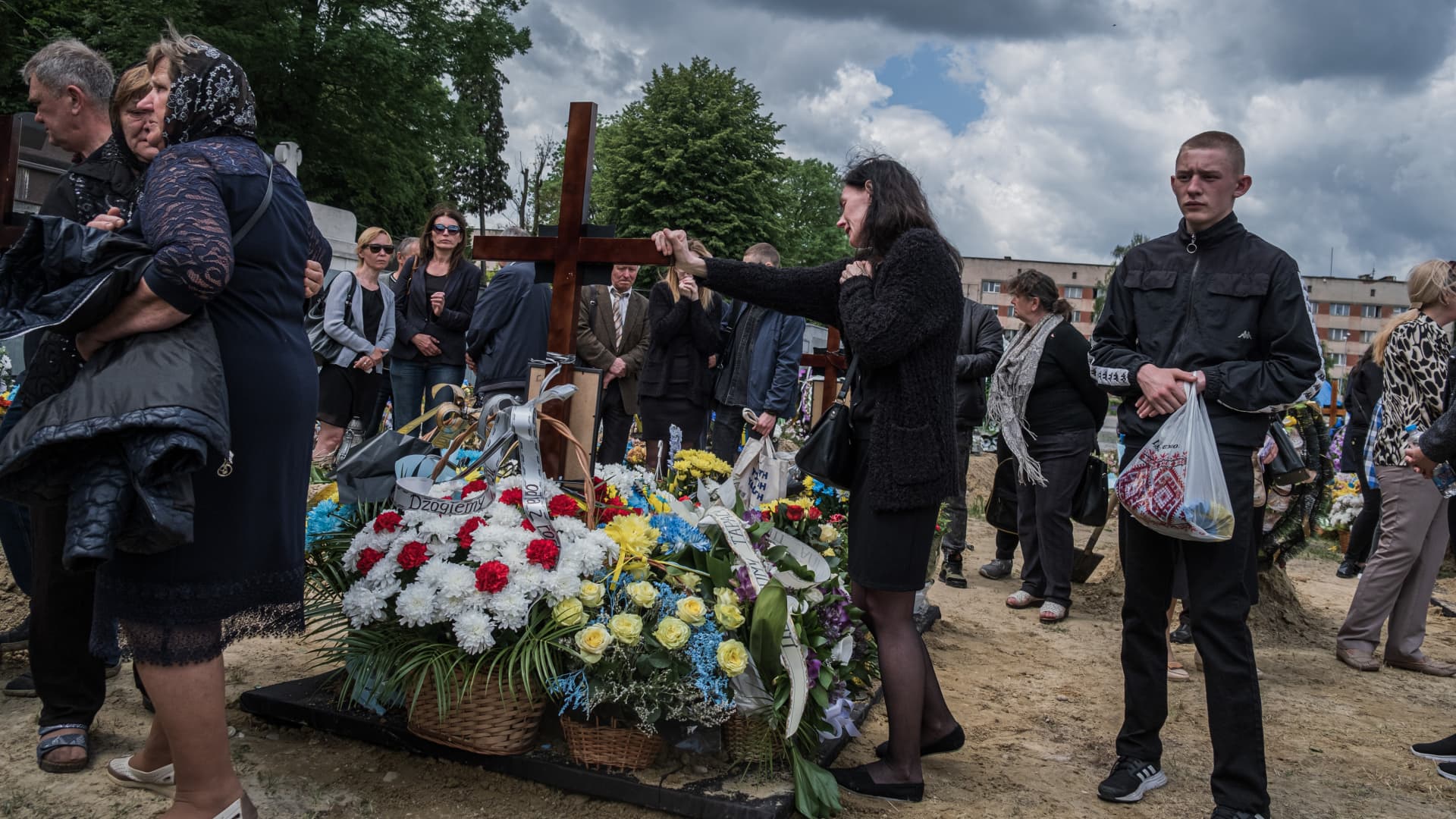 Relatives of the fallen soldiers pay their final respects by the graves at the cemetery after the funeral of the fallen soldiers in Lviv, Ukraine on May 26, 2022. The number of soldiers who lost their lives is increasing day by day and different burial sites are opened to bury people, as in Lviv.