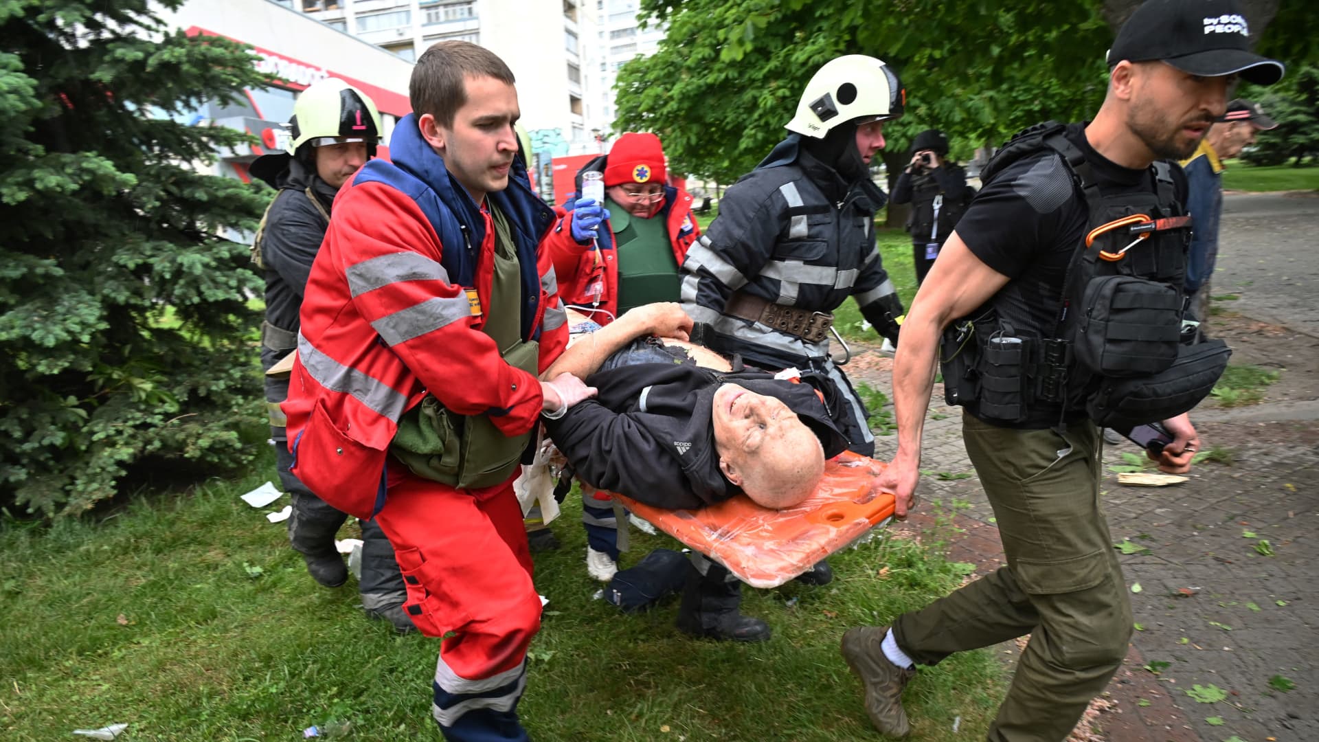 Paramedics and emergency workers carry a man wounded in shelling in Kharkiv on May 26, 2022, on the 91st day of Russia's invasion of Ukraine.