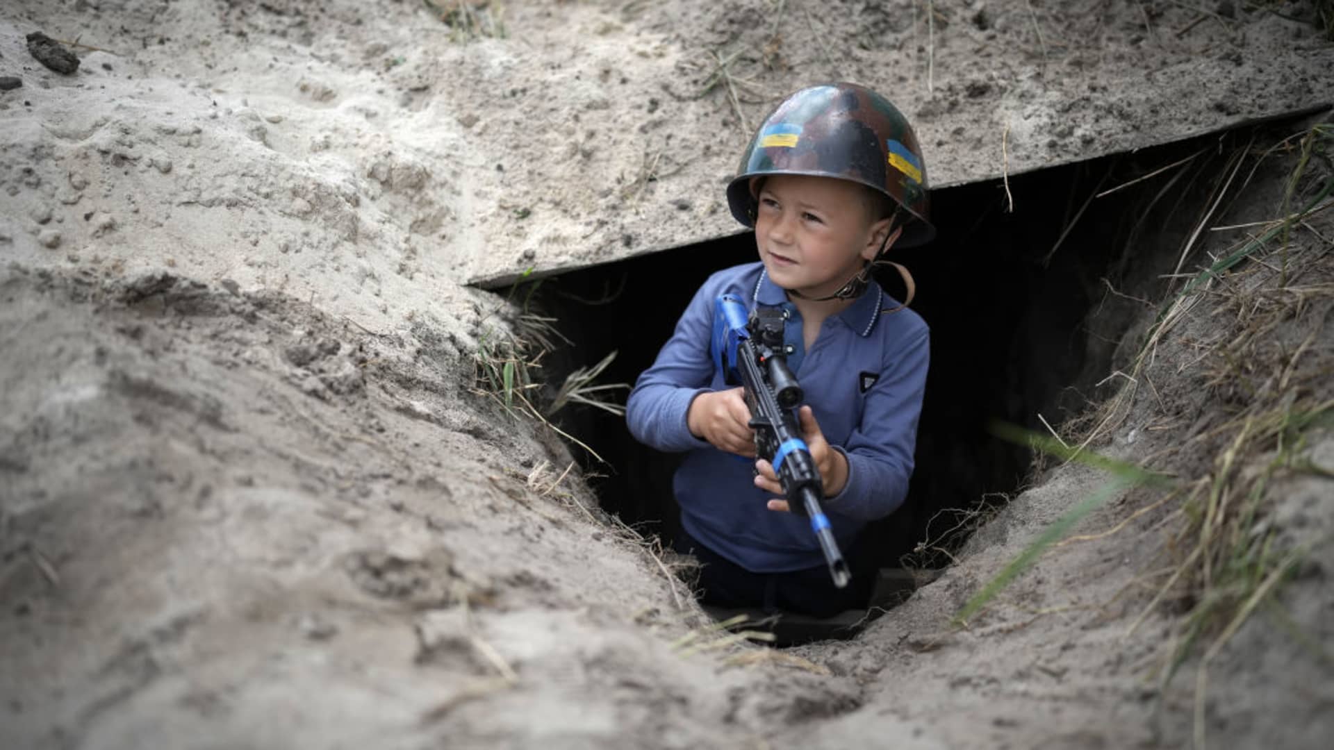 STOYANKA, UKRAINE - MAY 27: Ukrainian boy Valentyn 6, poses in the trench that he and his friend Andrii have dug at their makeshift checkpoint in their village next to a school crossing. The two boys have become well known to passing motorists on May 27, 2022 in Stoyanka, Ukraine. As Russia concentrates its attack on the east and south of the country, residents of the Kyiv region are returning to assess the war's toll on their communities. The towns around the capital were heavily damaged following weeks of brutal war as Russia made its failed bid to take Kyiv.(Photo by Christopher Furlong/Getty Images)