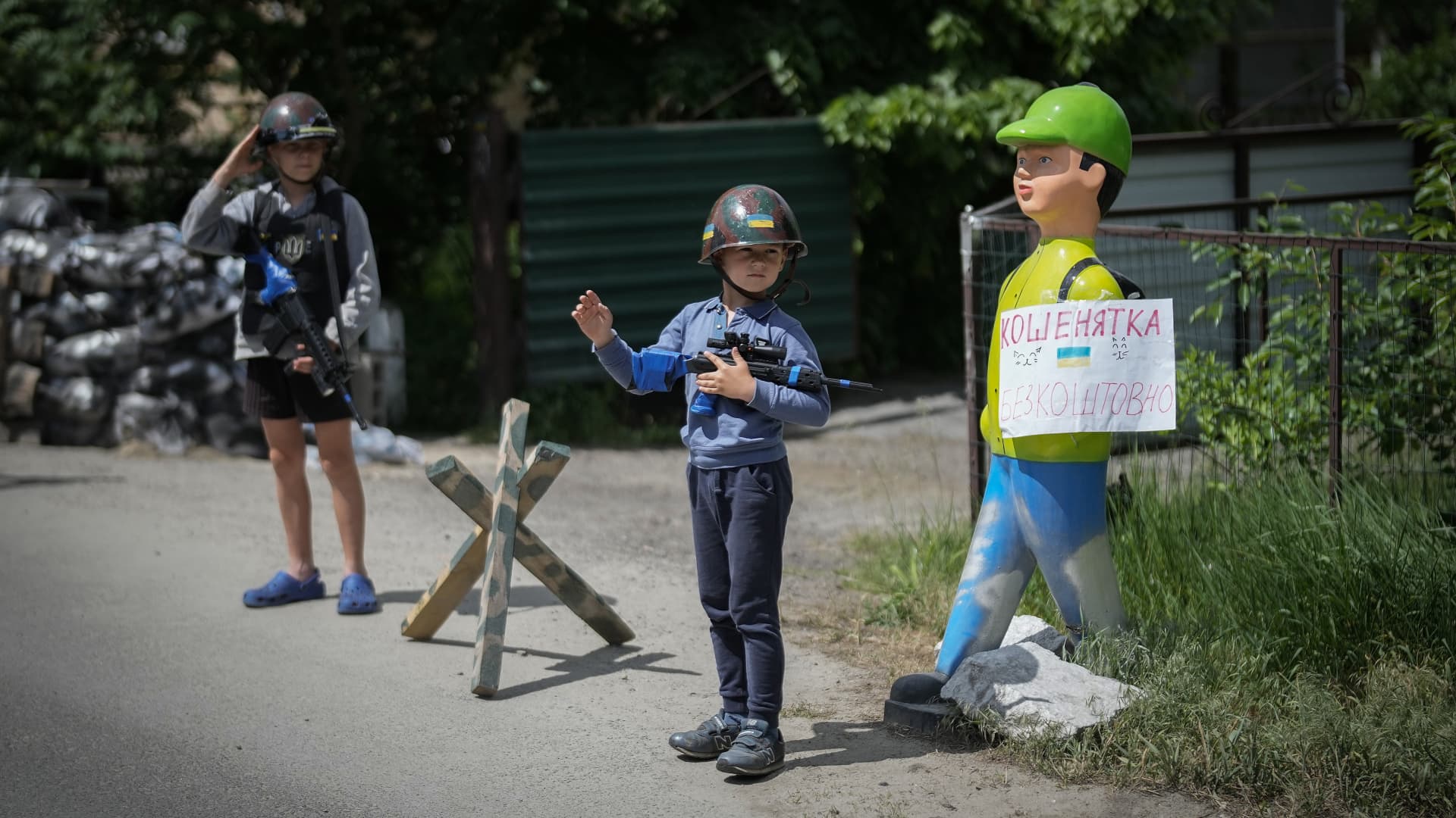 Ukrainian boys Andrii, aged 12 and his friend Valentyn 6, play at being soldiers and man their makeshift checkpoint in their village next to a school crossing. The two boys have become well known to passing motorists on May 27, 2022 in Stoyanka, Ukraine. 