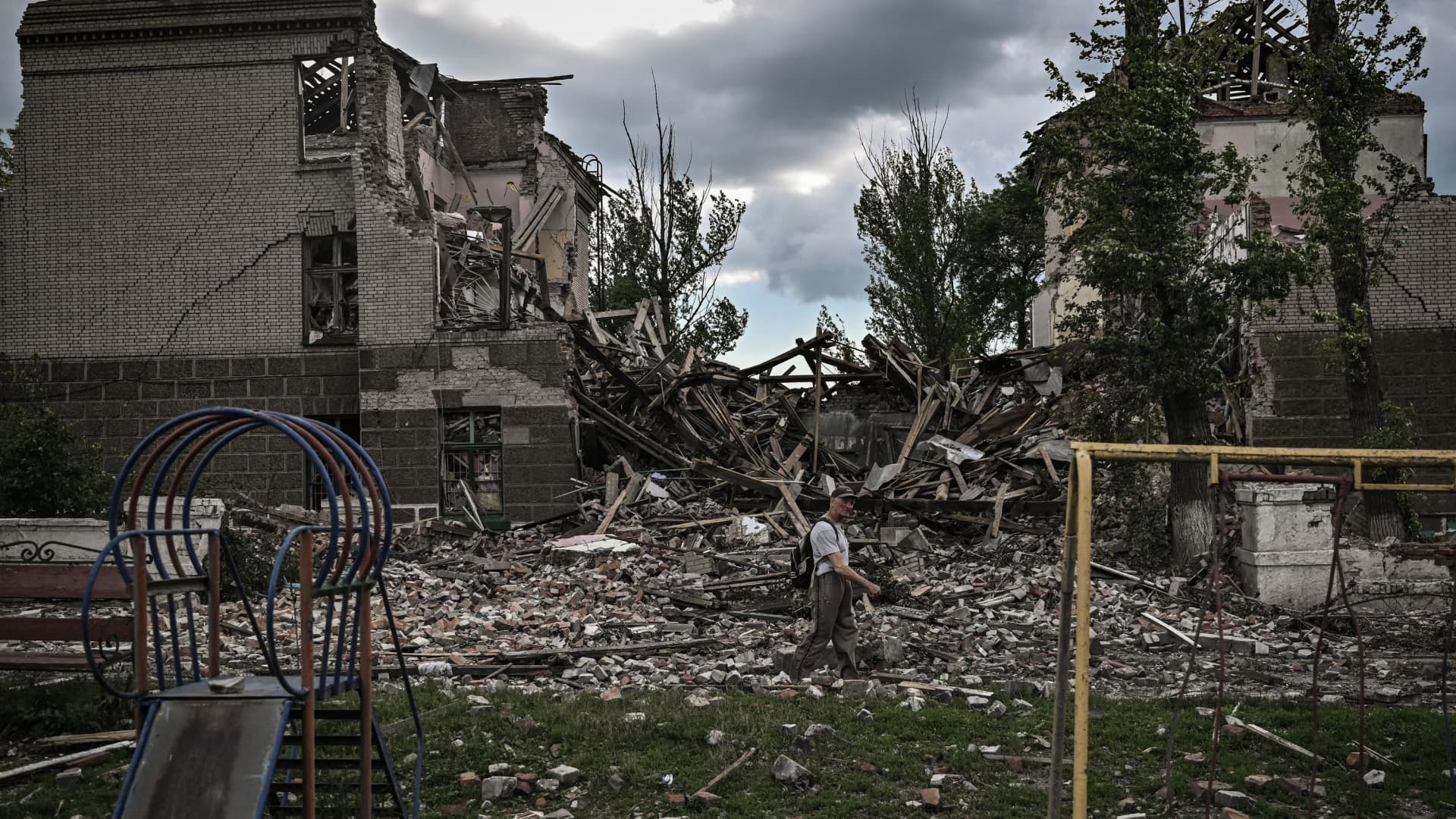 A man walks in front of a destroyed school in the city of Bakhmut, in the eastern Ukrainian region of Donbas, on May 28, 2022.