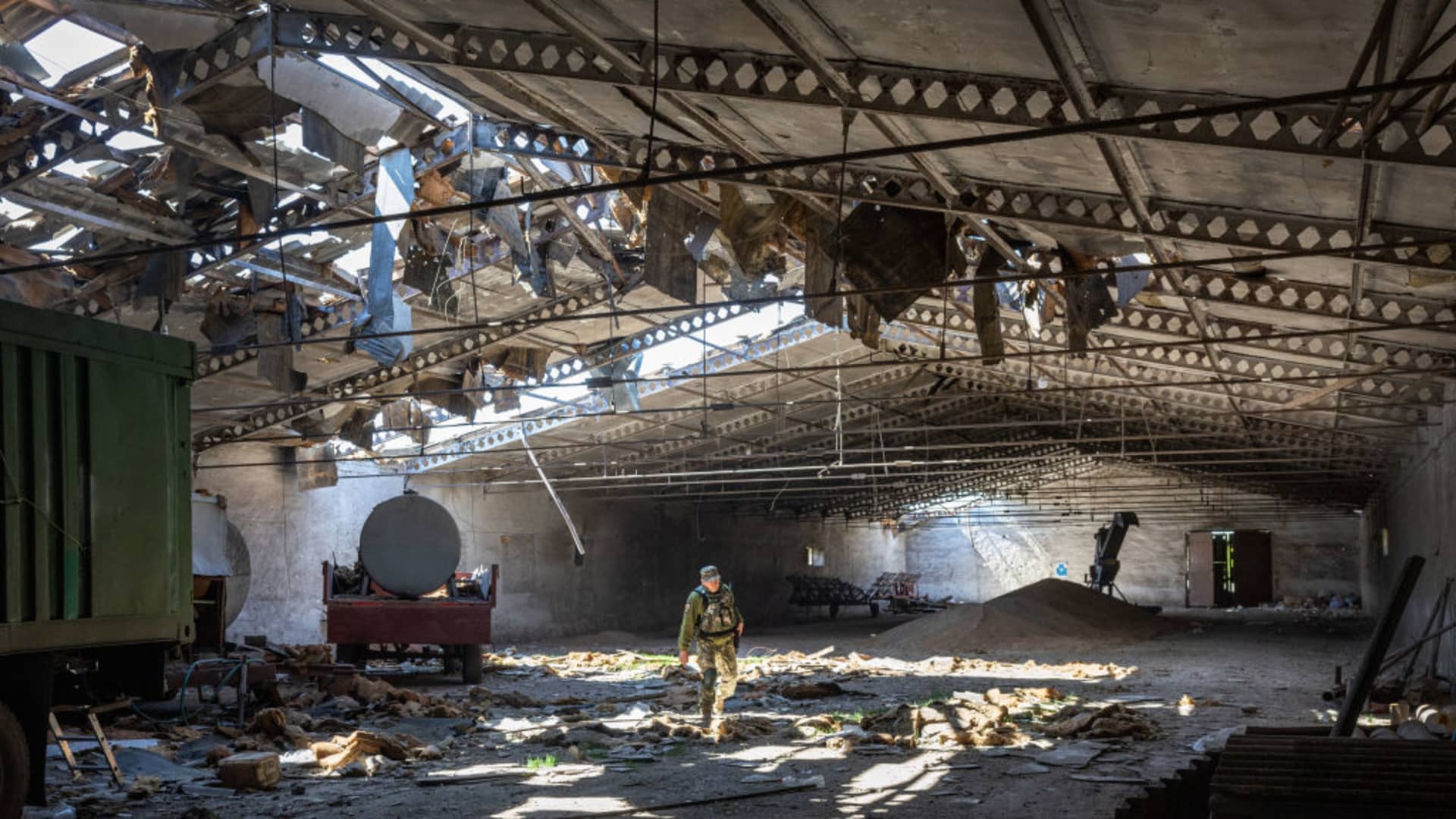 A Ukrainian army officer inspects a grain warehouse shelled by Russian forces on May 6, 2022, near the front lines of Kherson Oblast in Novovorontsovka, Ukraine. Russia has been accused of targeting food storage sites in front-line areas and disrupting Ukraine's wheat production, potentially causing a global shortage.