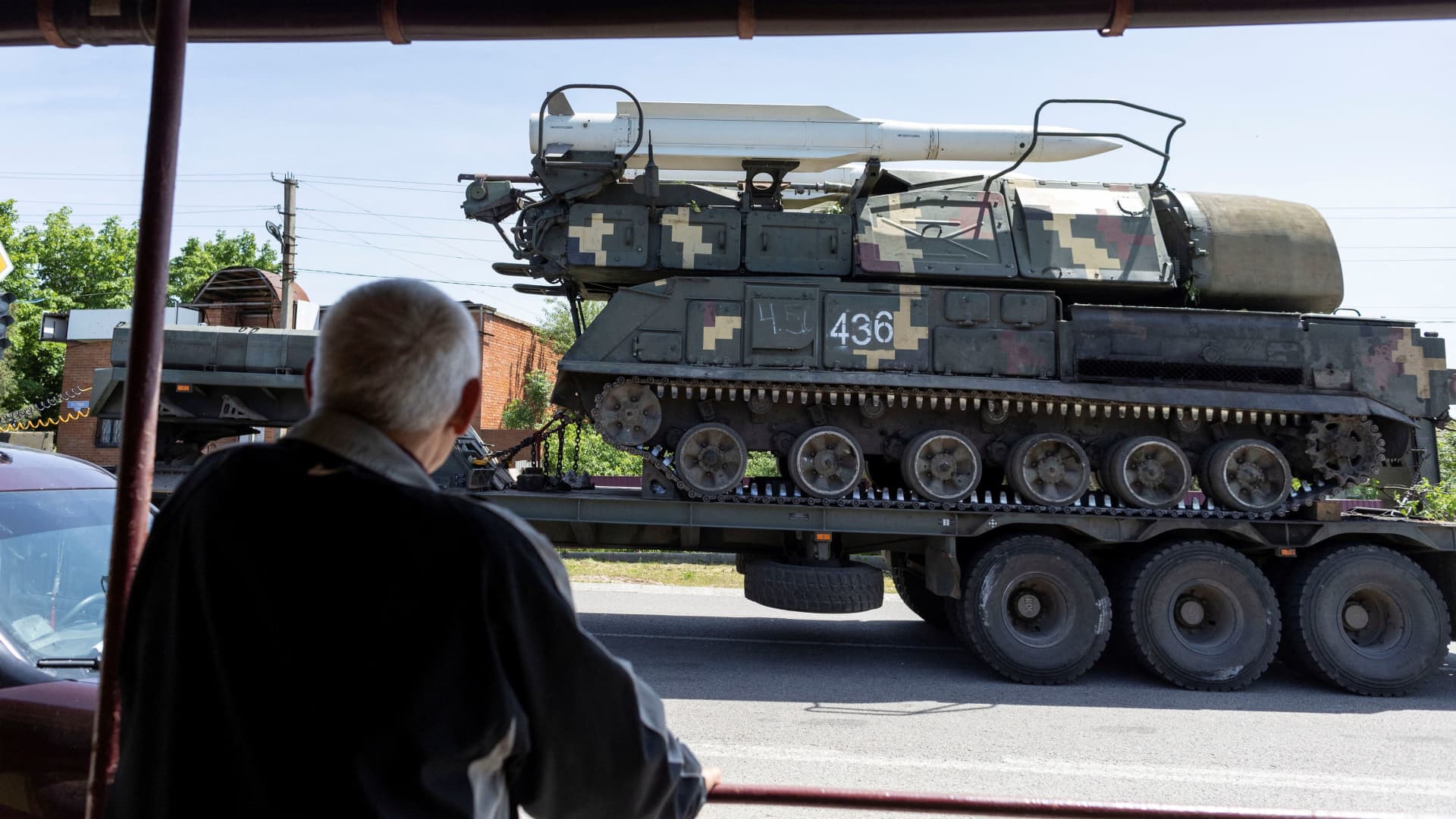 A local resident looks at a rocket launcher vehicle being transported, amid Russia's invasion of Ukraine, near Kramatorsk, Donetsk region, Ukraine, May 30, 2022 