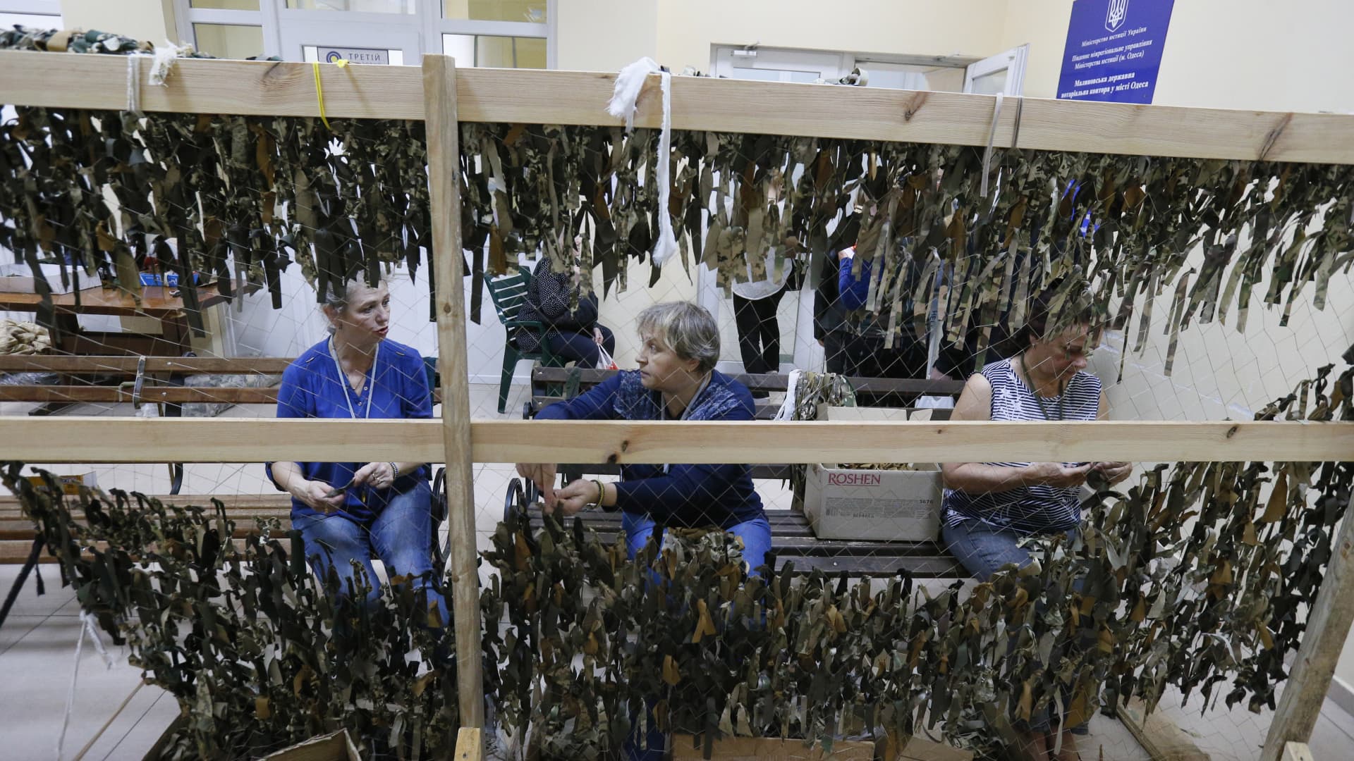 People weave camouflage nets in a weaving camouflage nets center in Odessa, Ukraine, on May 30, 2022. Ukrainian volunteers mark the 500th net which they made for the Ukrainian army. 