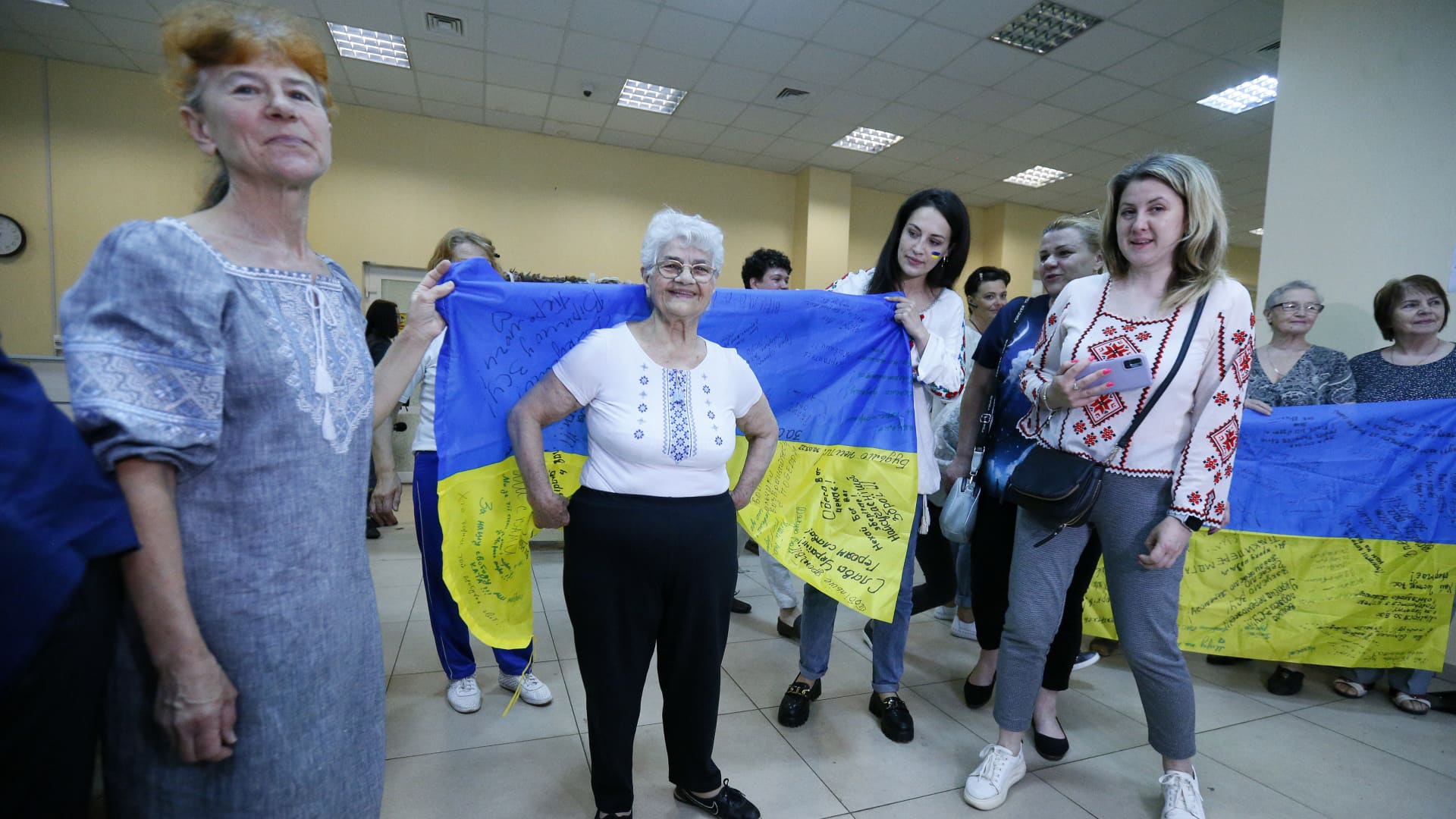 People show signed Ukrainian flags in a weaving camouflage nets center in Odessa, Ukraine, on May 30, 2022. 