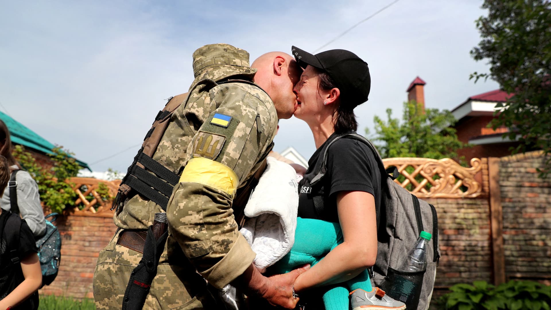A woman carries a baby as she reacts after evacuating from Russian troop-occupied Kupiansk town in a bus convoy, amid Russia's attack on Ukraine, on the outskirts of Kharkiv, Ukraine May 30, 2022. Picture taken May 30, 2022. 