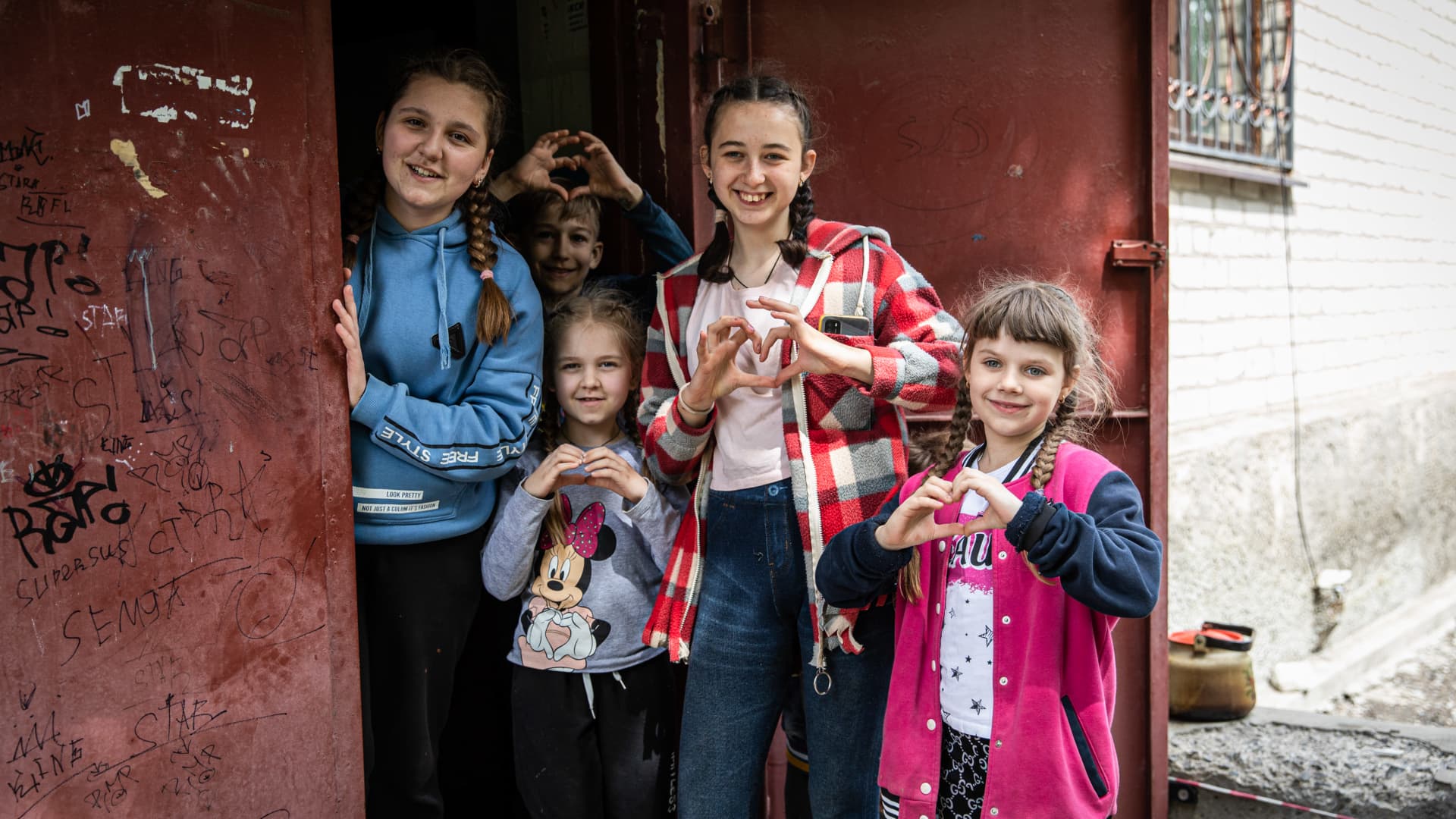 Children living in an underground bomb shelter show a heart sign outside their shelter. As Russian troops launched the offensive from multiple directions, hoping to cut off Ukrainian supplies and reinforcements from the Donbas region, the town of Lysychansk connecting to Severodoonetsk was heavily bombed, and people chose to live underground under heavy shelling.