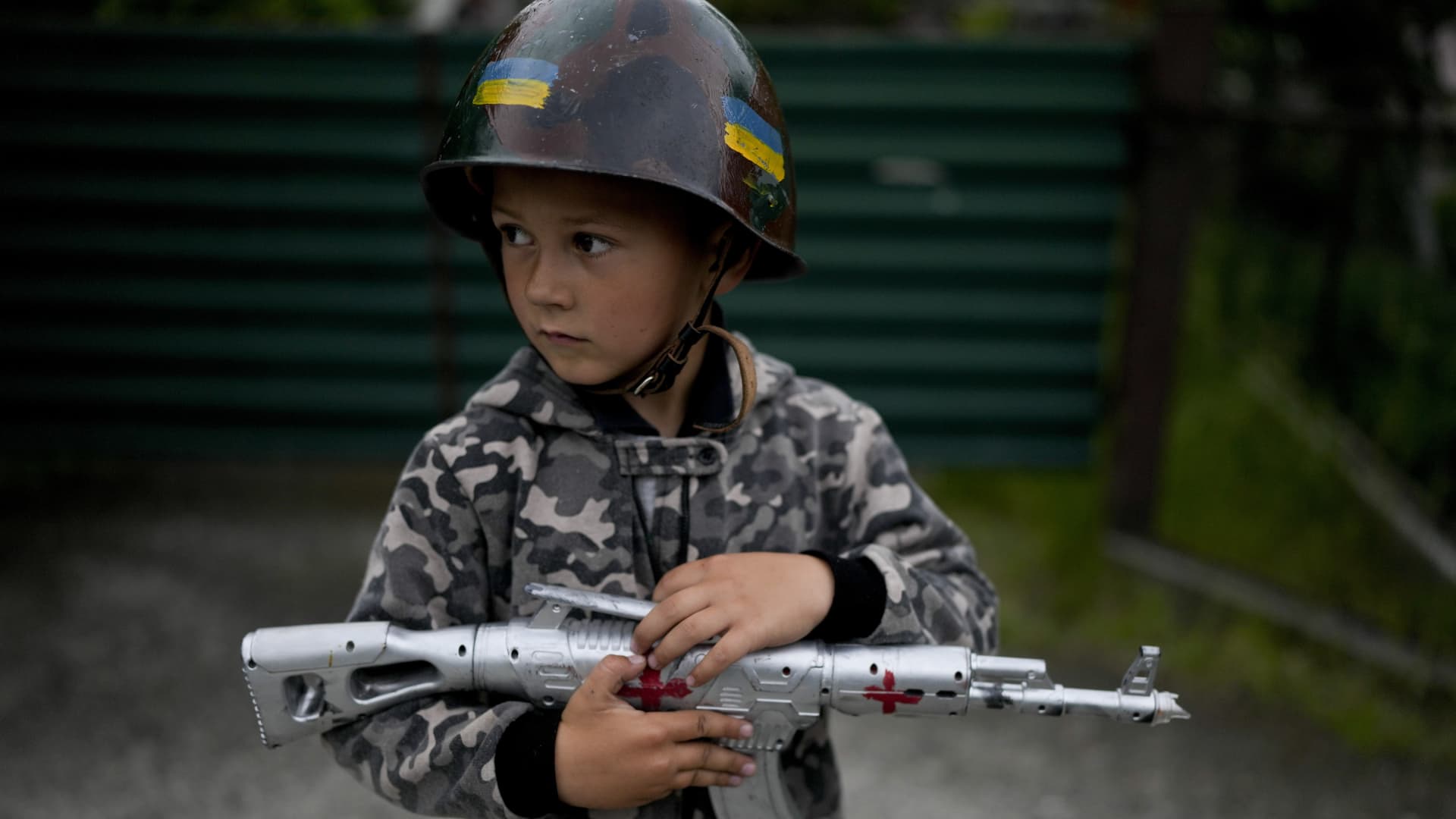 Valik Vladimirovich plays dressed as a soldier in Stoyanka outskirts Kyiv, Ukraine, Monday, May 30, 2022.