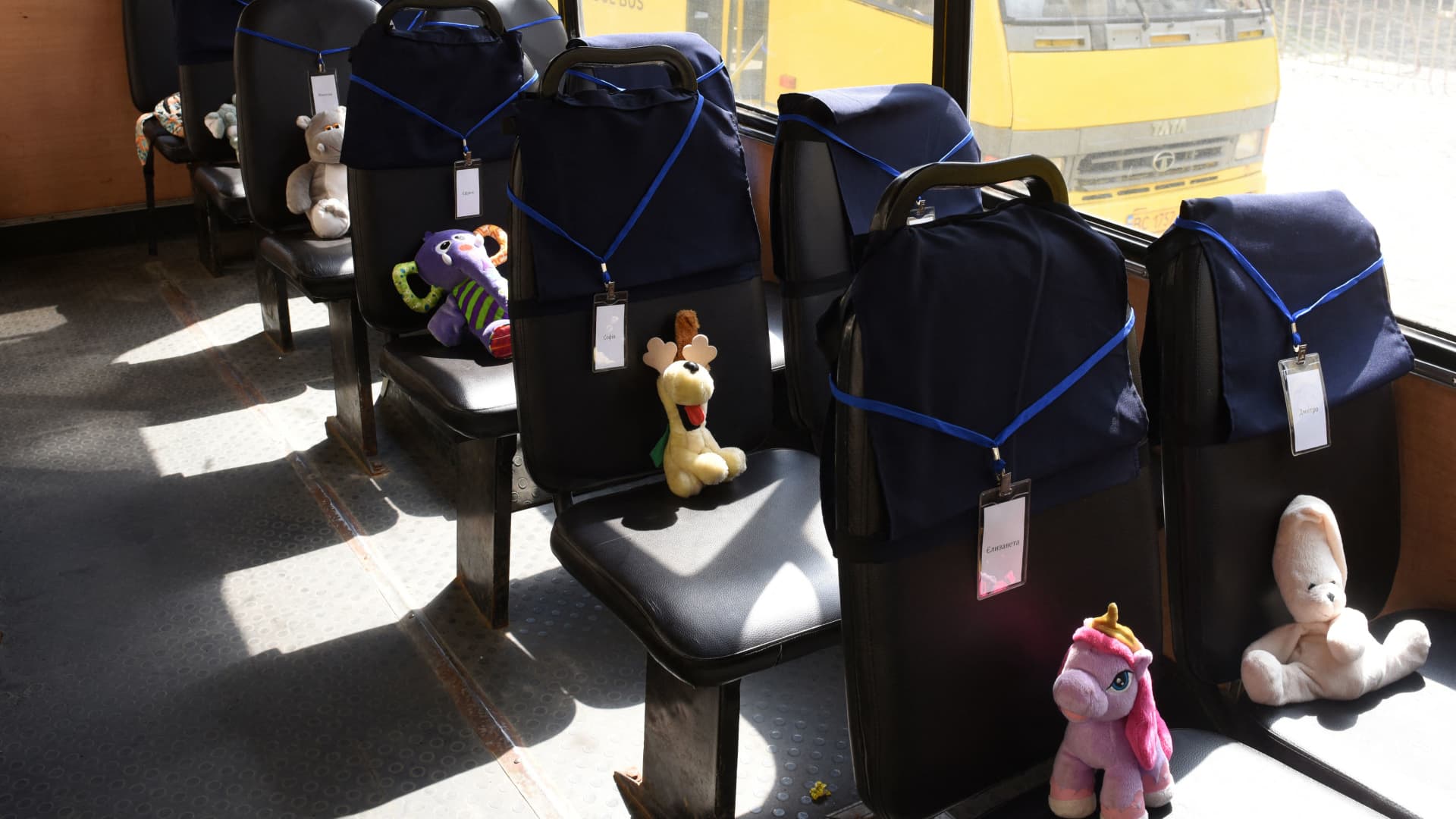 Stuffed toys symbolizing each of 243 killed Ukrainian children sit on seats in an empty yellow school buss during an action marking the International Children's Day, in Lviv on June 1, 2022, amid the Russian invasion of Ukraine. 