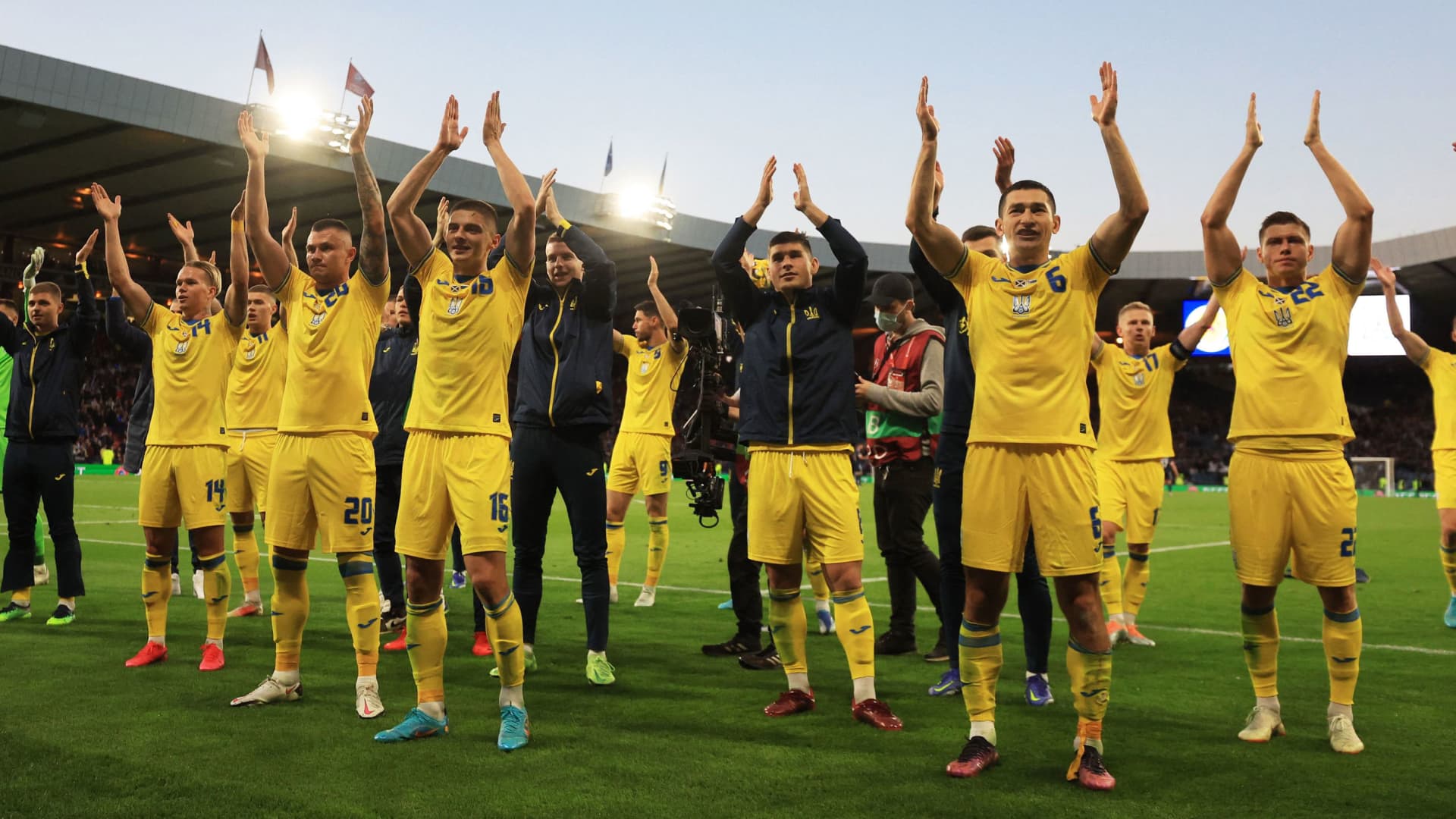 Ukraine players celebrate and applaud their fans after the match.