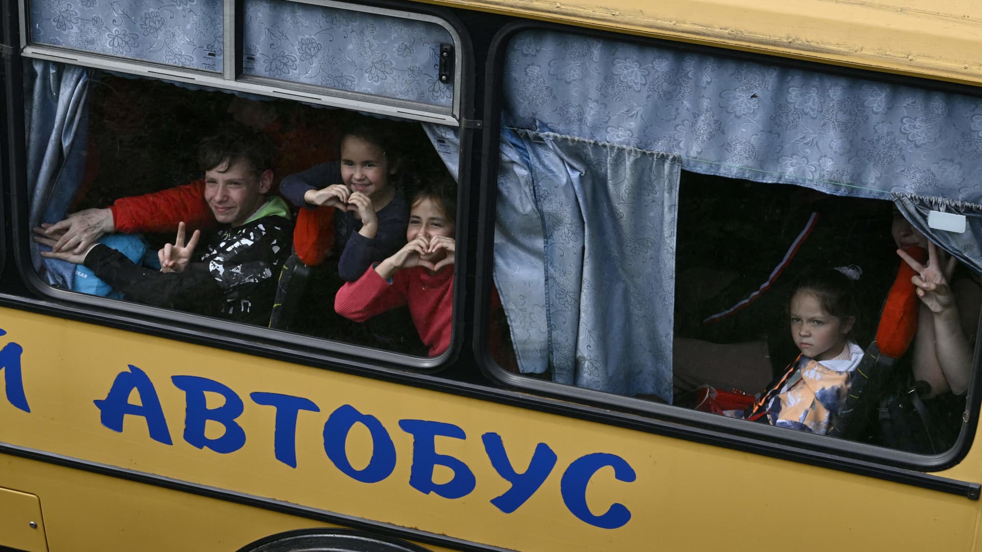 Ukrainian evacuees react in a bus while they drive on a road east of Kharkiv on May 30, 2022, amid Russian invasion of Ukraine.