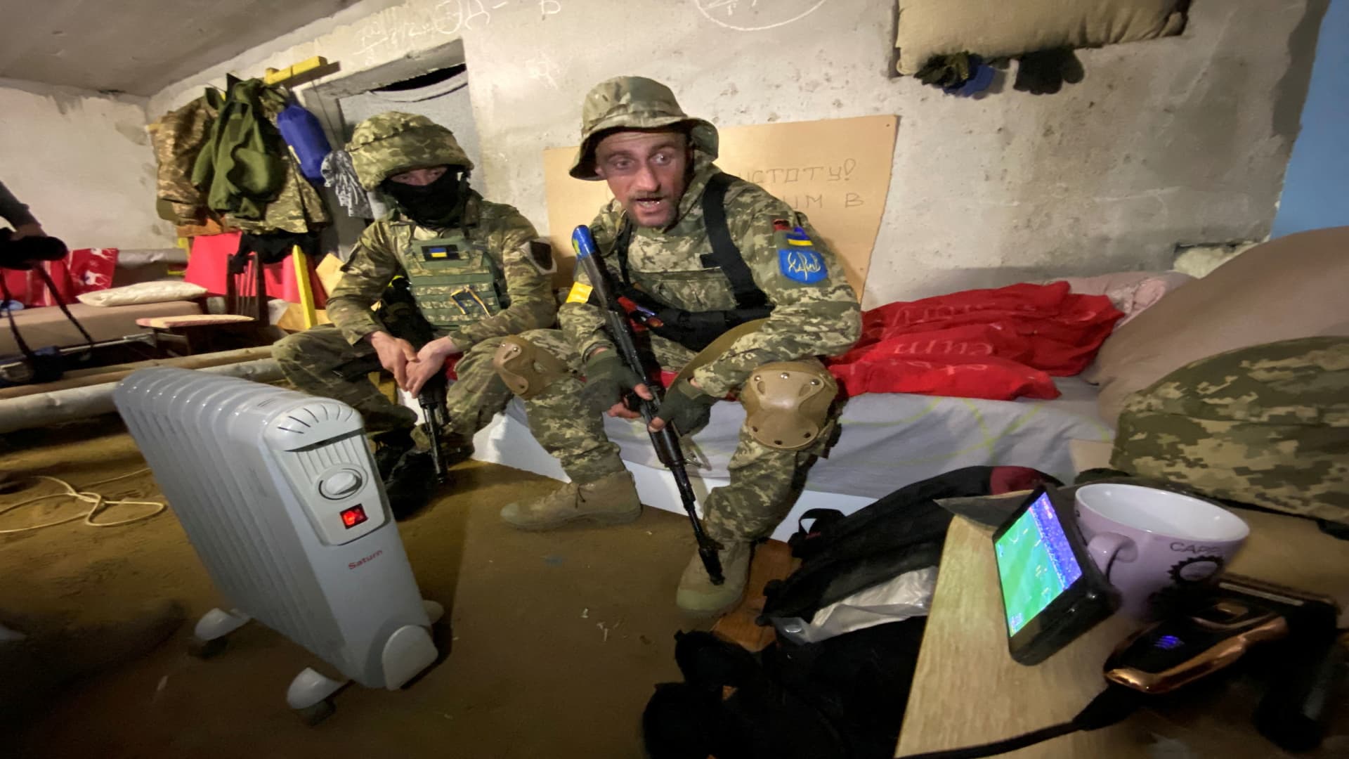 Members of the Ukrainian Territorial Defense Forces watch the FIFA World Cup 2022 qualification playoff semi-final soccer match between Scotland and Ukraine on a mobile phone in a shelter, as Russia's attack on Ukraine continues, in Kharkiv, Ukraine June 1, 2022. Picture taken June 1, 2022. 