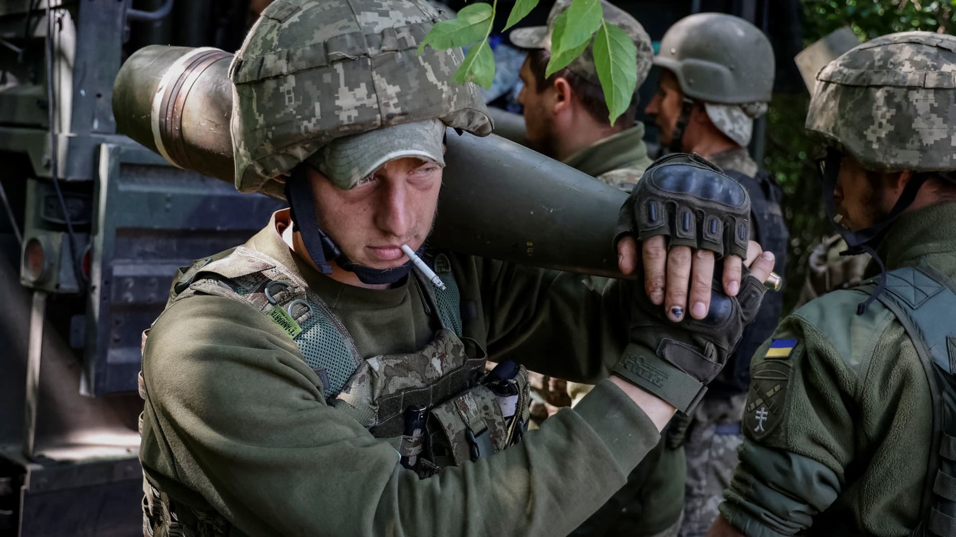 Ukrainian service members carry shells to be used by a M777 Howitzer near a frontline, in Donetsk Region, Ukraine June 6, 2022.