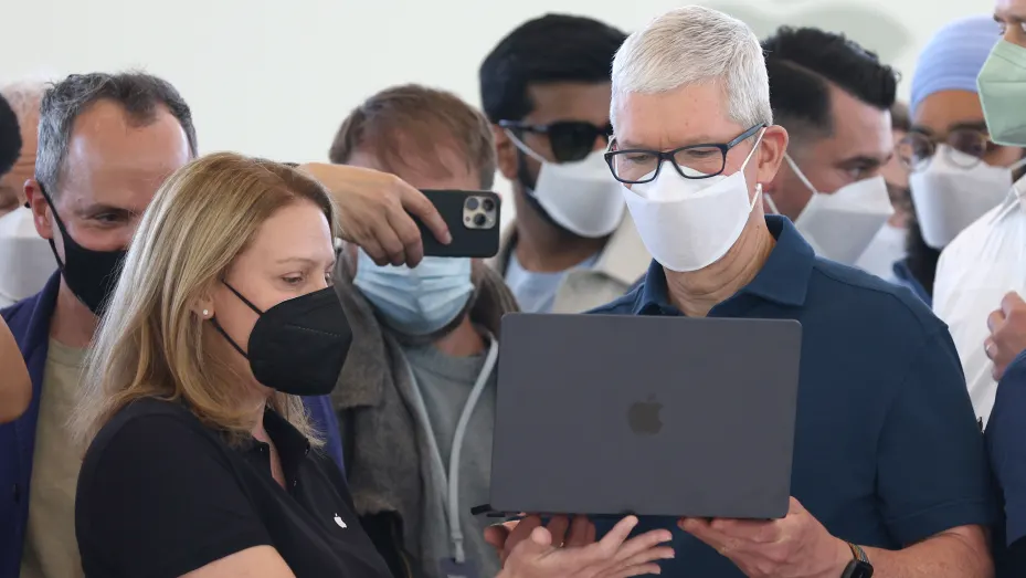 Apple CEO Tim Cook (R) looks at a newly redesigned MacBook Air laptop during the WWDC22 at Apple Park on June 06, 2022 in Cupertino, California. Apple CEO Tim Cook kicked off the annual WWDC22 developer conference.