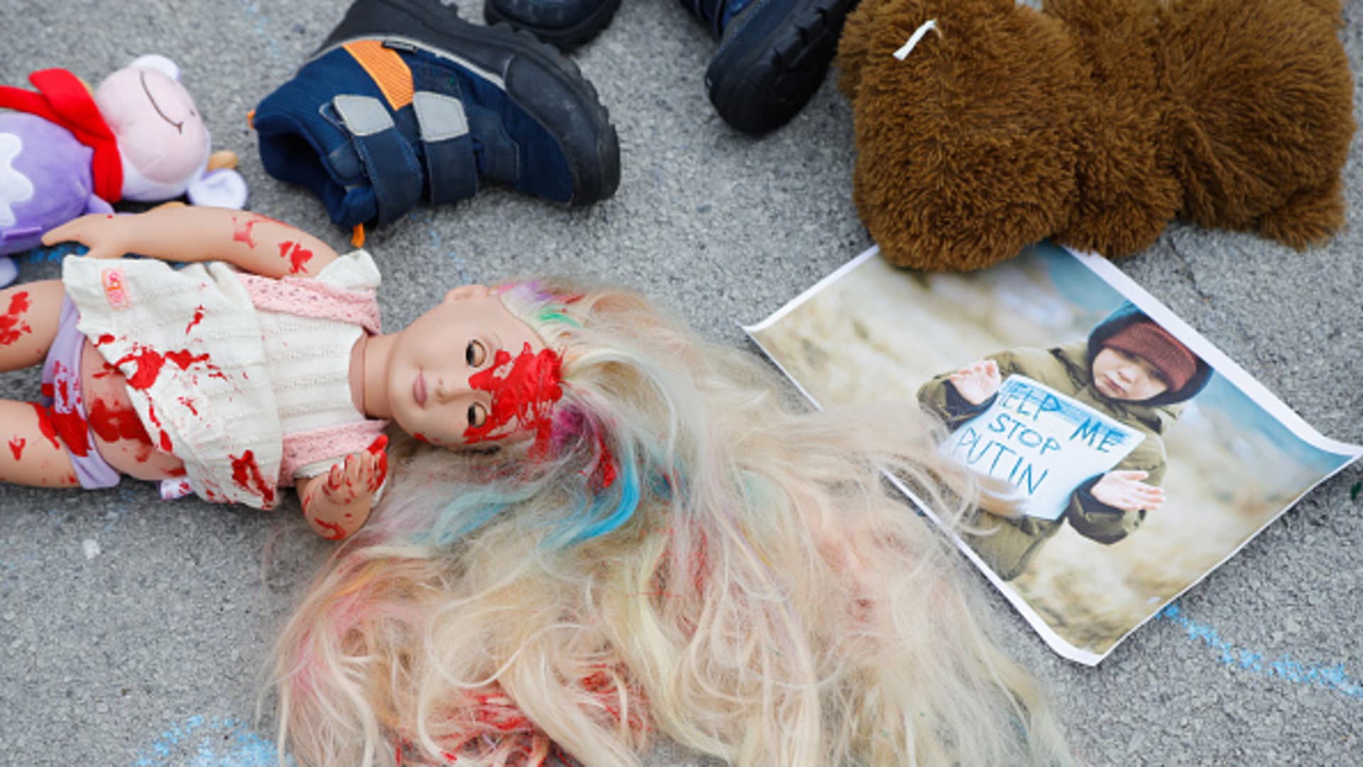 A child's doll stained with red paint lays on the ground during a Europe-wide rally for protection of Ukrainian children affected by the war in Ukraine. Over 240 children have been reported killed in the war so far.