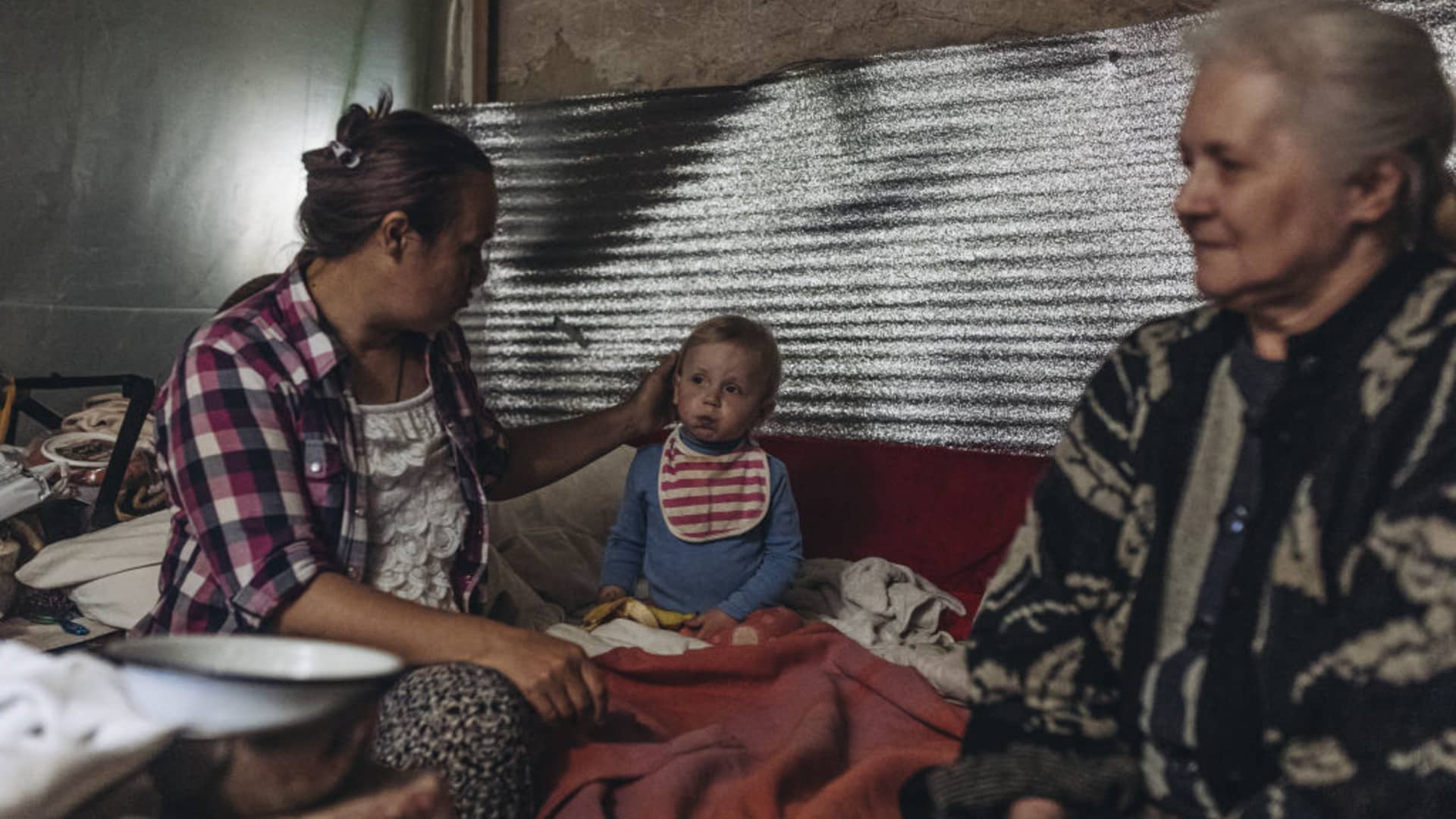 A mother and grandmother give care for a half-year-old child in a basement in Siversk, Donetsk Oblast, Ukraine, on May 31, 2022, as Russian attacks continue.
