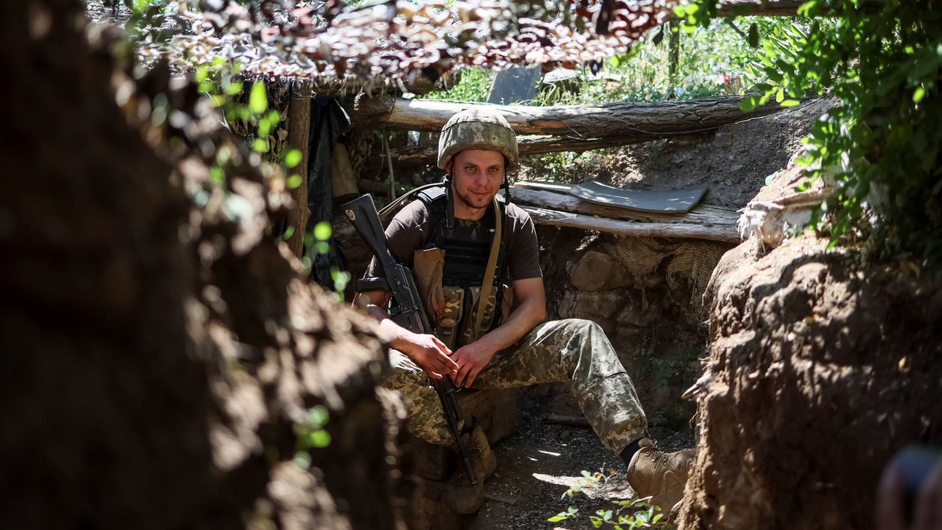 A Ukrainian service member sits in a trench at a position on the front line, amid Russia's attack on Ukraine, near the town of New York, Donetsk region, Ukraine June 9, 2022. 