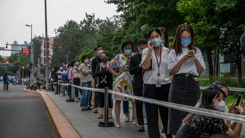 BEIJING, CHINA - JUNE 09: People wait in line for nucleic acid tests to detect COVID-19 at a testing site on June 9, 2022 in Beijing, China. China says it has generally controlled recent outbreaks in Beijing after hundreds of people tested positive for the virus in recent weeks. Local authorities have initiated mass testing, mandated proof of a negative PCR test within 72 hours to enter most public spaces and locked down some neighborhoods in an effort to maintain the country's zero COVID strategy. Due to i