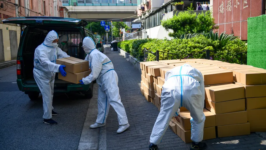 Staff members of China Post unload parcels of daily necessities for residents quarantined at home from a minivan on May 14, 2022 in Shanghai, China.