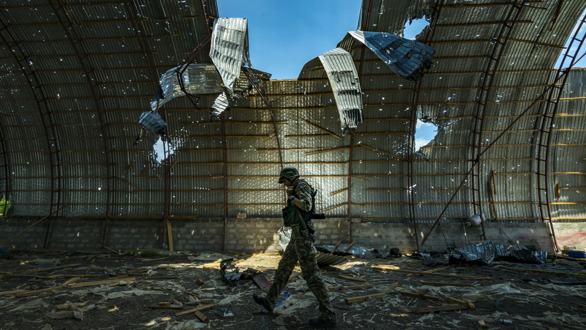 A ukrainian soldier walks inside a destroyed barn by russian shelling near the frontline of the Zaporizhzhia province, Ukraine. Harvest can not be collected in the area because the constant combats between russian and ukrainian armies in the fields.