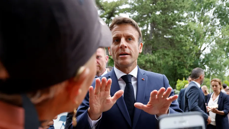 France's President Emmanuel Macron speaks to fellow voters as he arrives to vote in the second stage of French parliamentary elections at a polling station in Le Touquet, northern France on June 19, 2022.