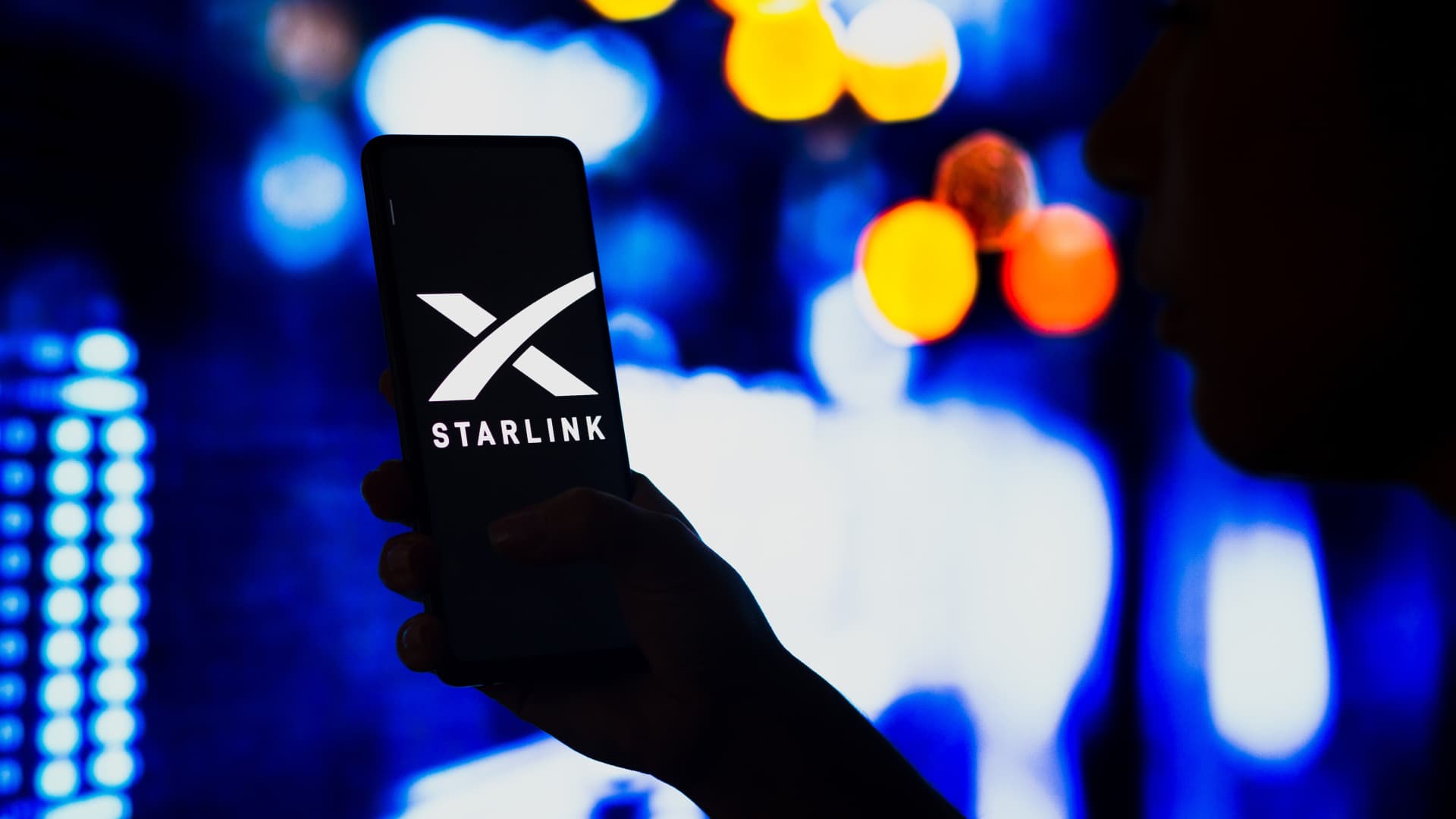 A smartphone with the Starlink logo displayed on the screen.