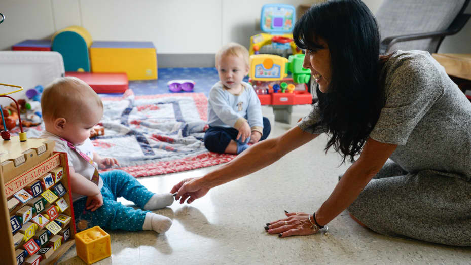 Jenny Goff, right, reaches out to a child at Central Park Child Care Center in Vancouver, Washington.