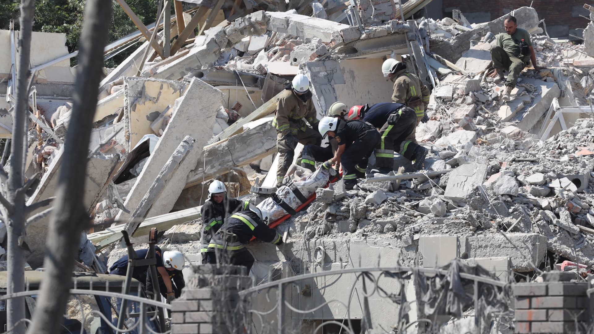 Rescuers evacuate the body of a person from a destroyed building after being hit by a missile strike in the Ukrainian town of Serhiivka, near Odessa, killing at least 18 people and injuring 30, on July 1, 2022.