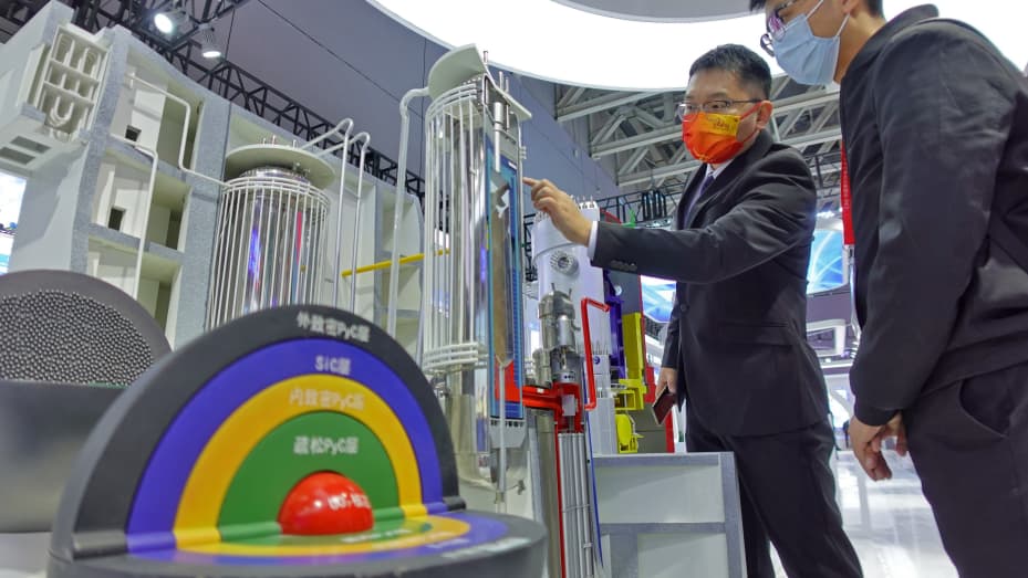 A visitor (R) learns about huaneng's high-temperature gas-cooled reactor model at the China International Nuclear Power Industry and Equipment Exhibition 2021 in Yantai, Shandong Province, China, Oct. 19, 2021.