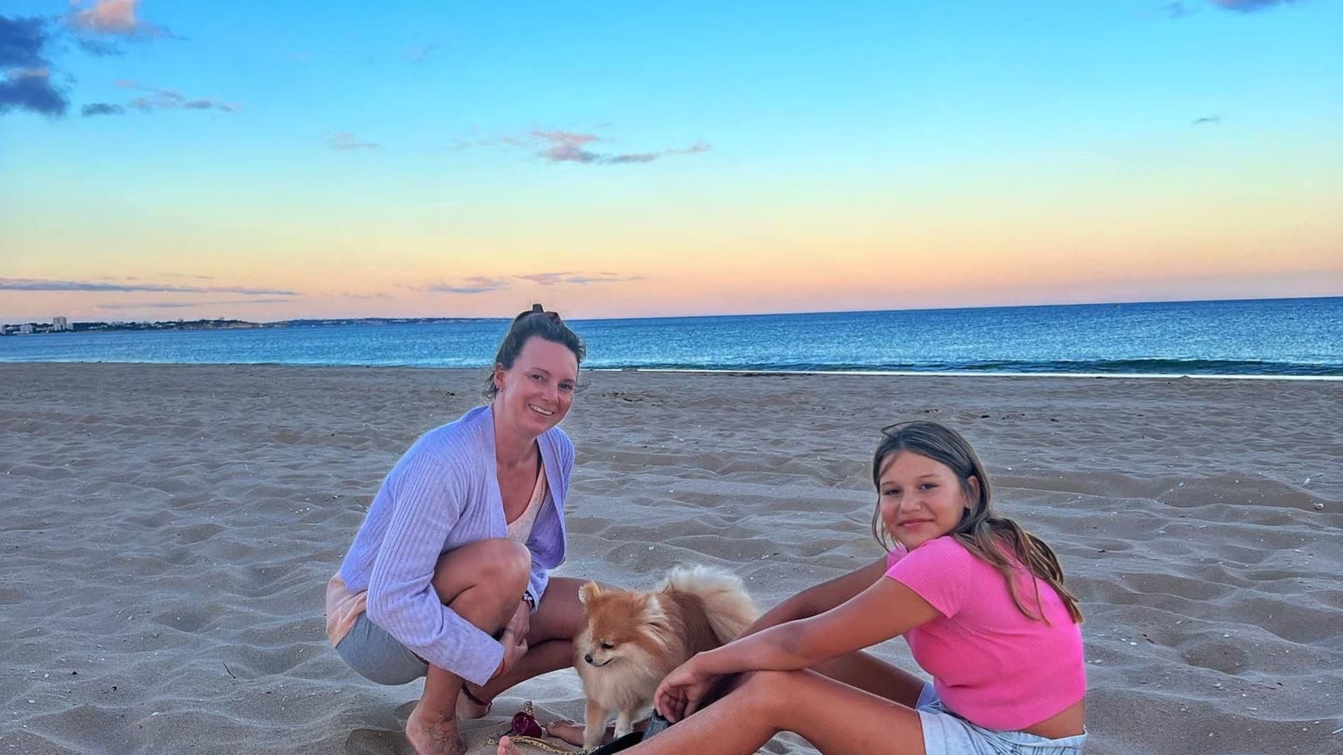 Teddy, the Taihuttus' dog, on a beach in Lagos, Portugal with Jessa and Romaine