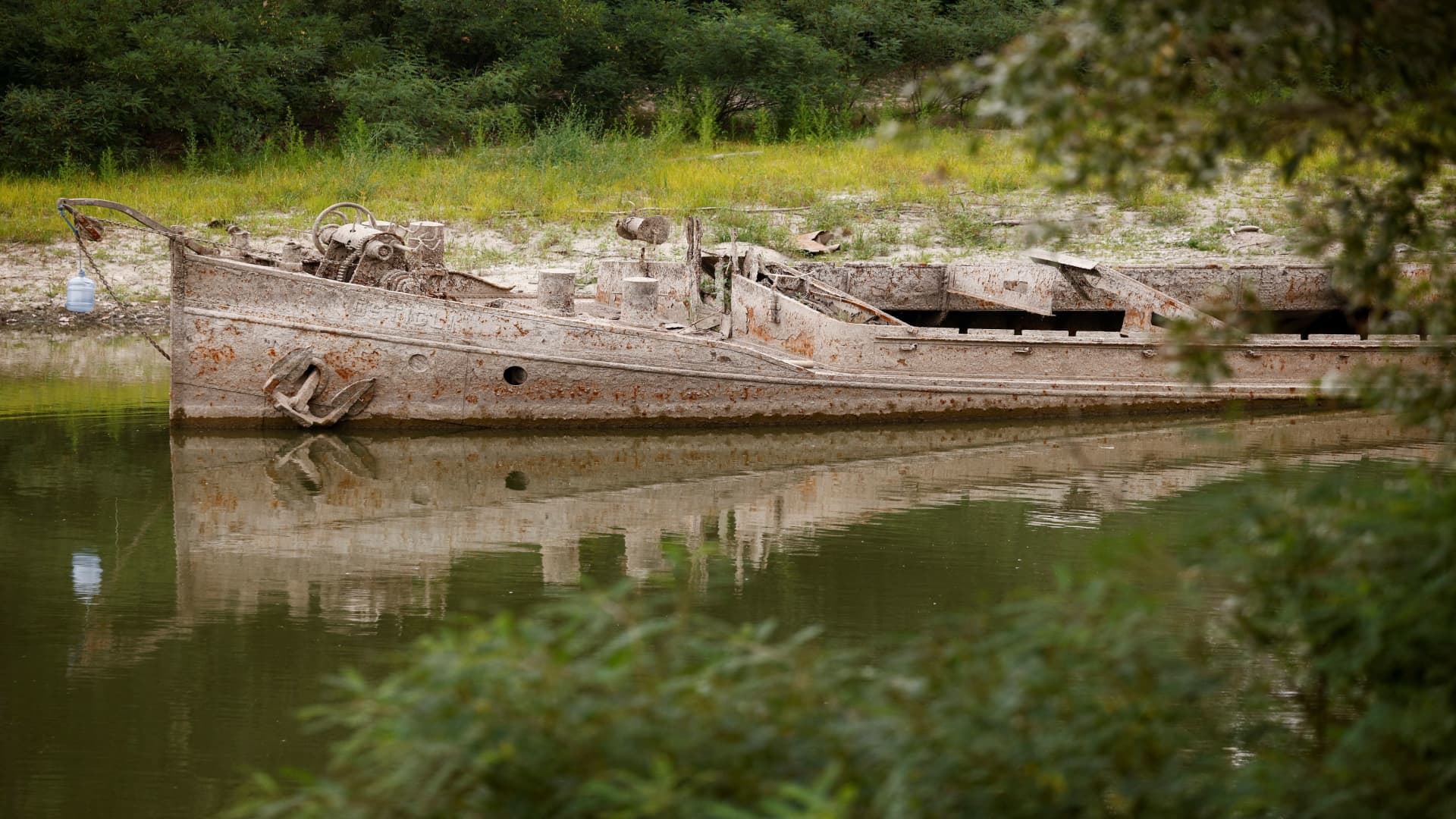 A barge that was sunk during WWII lies on Po's dry riverbed as parts of Italy's longest river and largest reservoir of freshwater have dried up due to the worst drought in the last 70 years, in Gualtieri, Italy, June 22, 2022. 