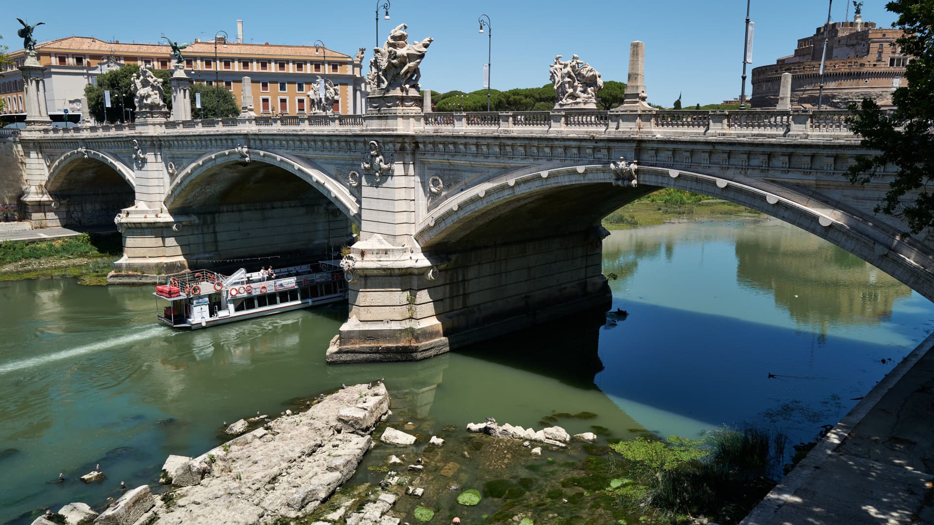 This picture taken on July 2, 2022 in Rome shows the low water level of the river Tiber near the Vittorio Emanuele II bridge, revealing an ancient bridge built under Roman Emperor Nero (Bottom).