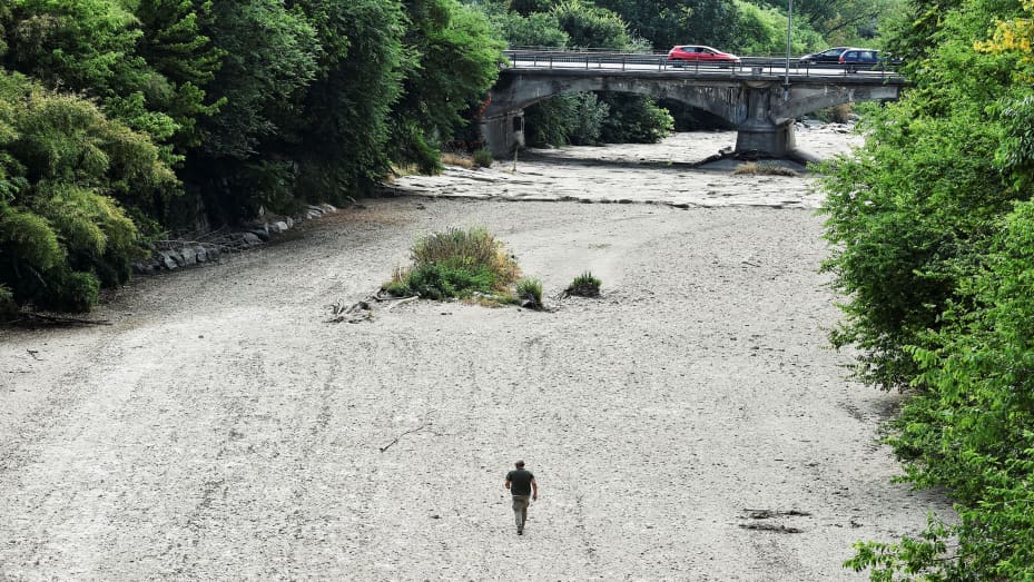 A man walks on the dry riverbed of Sangone river, a tributary of the Po river, which experiences its worst drought for 70 years, in Beinasco, Turin, Italy June 19, 2022. REUTERS / Massimo Pinca