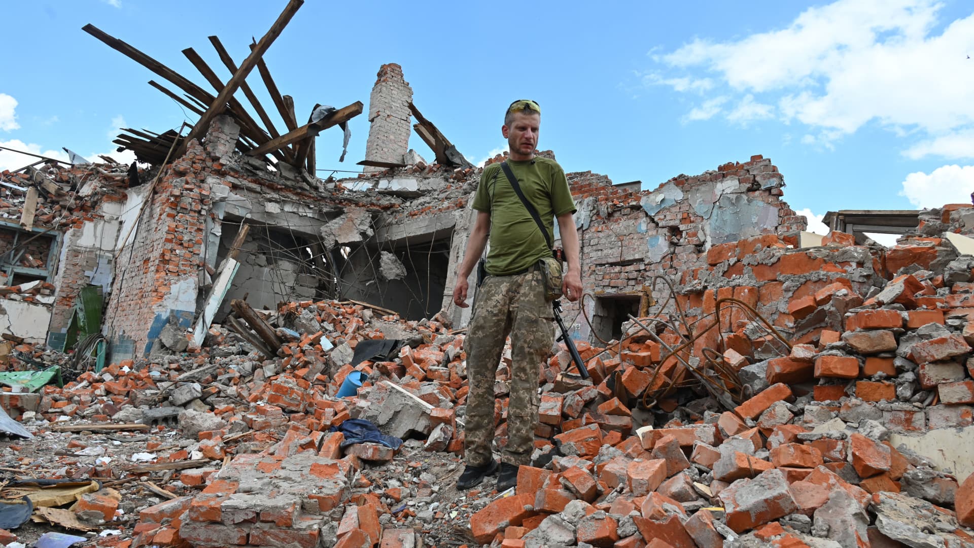 A Ukrainian serviceman inspects the ruins of Lyceum building, suspected to have been destroyed after a missile strike near Kharkiv on July 5, 2022, amid the Russian invasion of Ukraine.