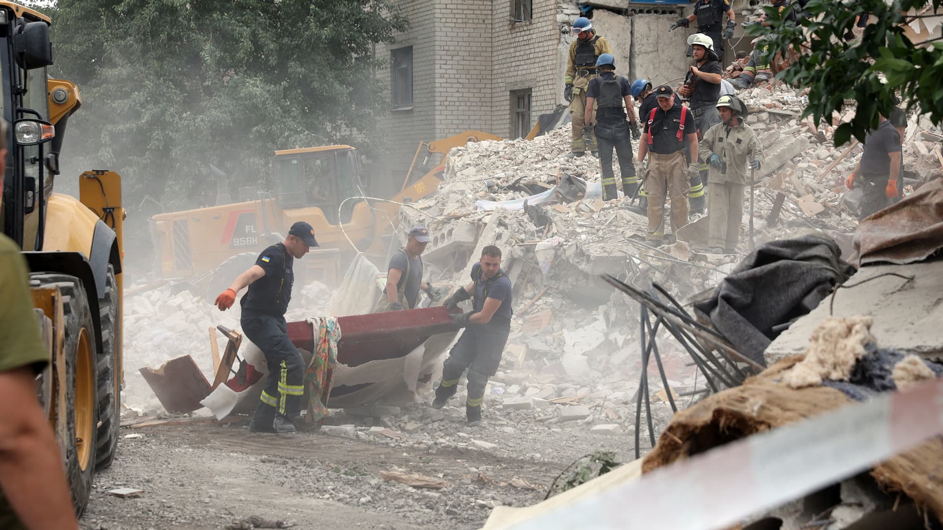 Rescuers clear the scene after a building was partially destroyed following shelling in Chasiv Yar, eastern Ukraine, on July 10, 2022. The building was hit by a Russian Hurricane missile, Pavlo Kyrylenko, governor of the Donetsk region that the Russian army is seeking to conquer, said on July 10, 2022 on Telegram.
