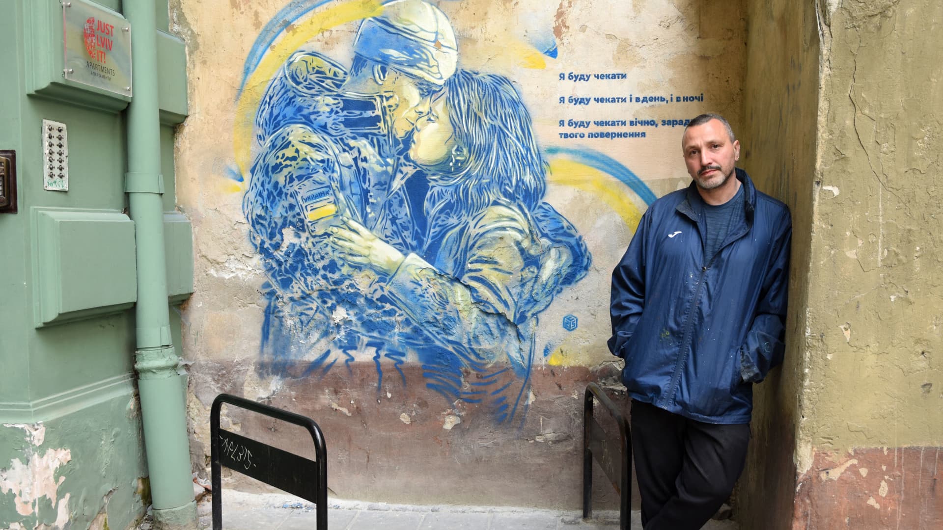 In this photograph taken on May 13, 2022, French street-artist Christian Guemy, known as C215, poses next one of his works in the western Ukrainian city of Lviv.