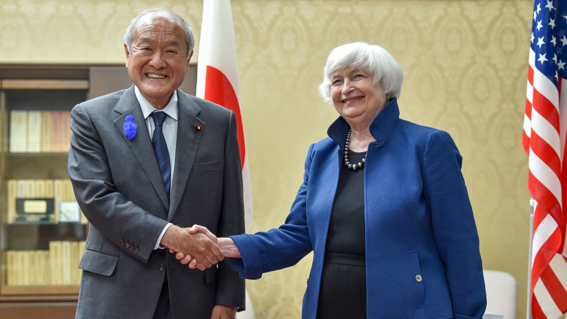 Japanese Finance Minister Shunichi Suzuki (L) shakes hands with US Treasury Secretary Janet Yellen in Suzuki's office in Tokyo on July 12, 2022.