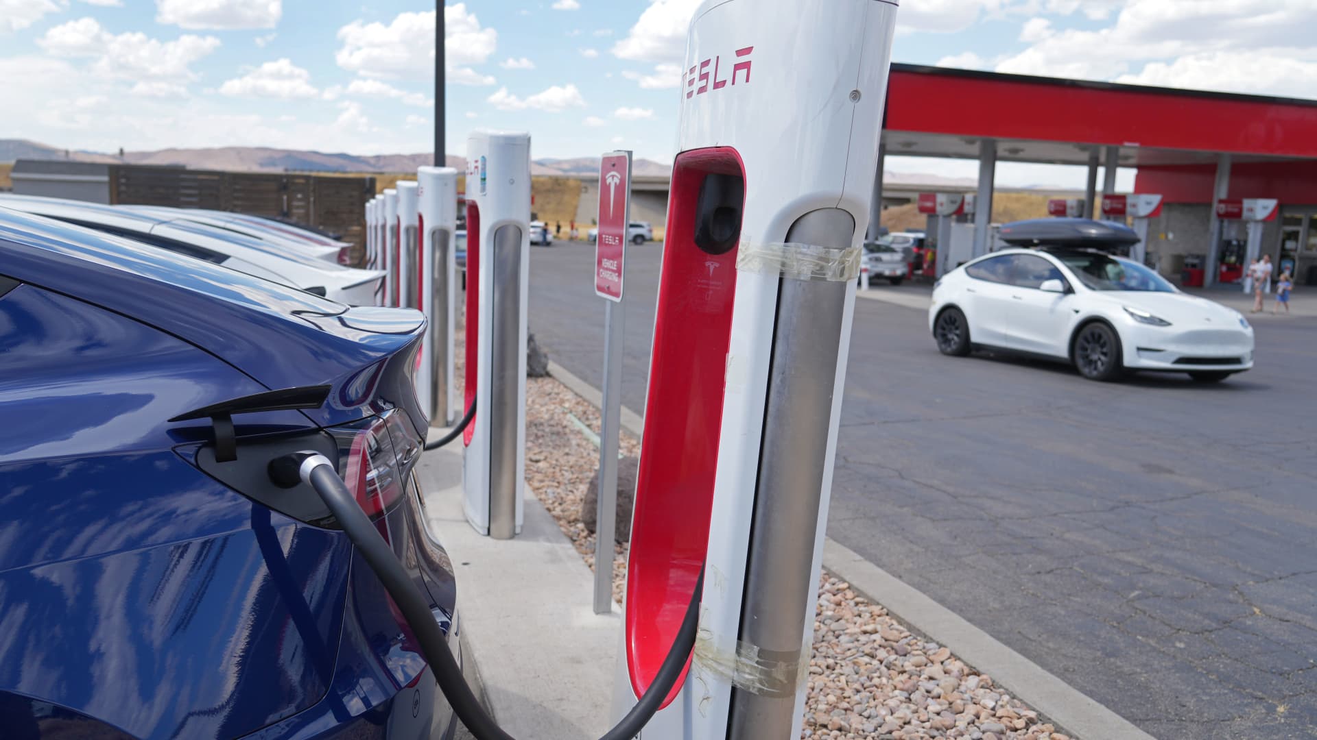 Tesla cars charge next to a traditional Texaco gas station on July 17, 2022 in Nephi, Utah. With more electric cars on the road, lack of charging infrastructure is becoming more of a problem for EV owners.