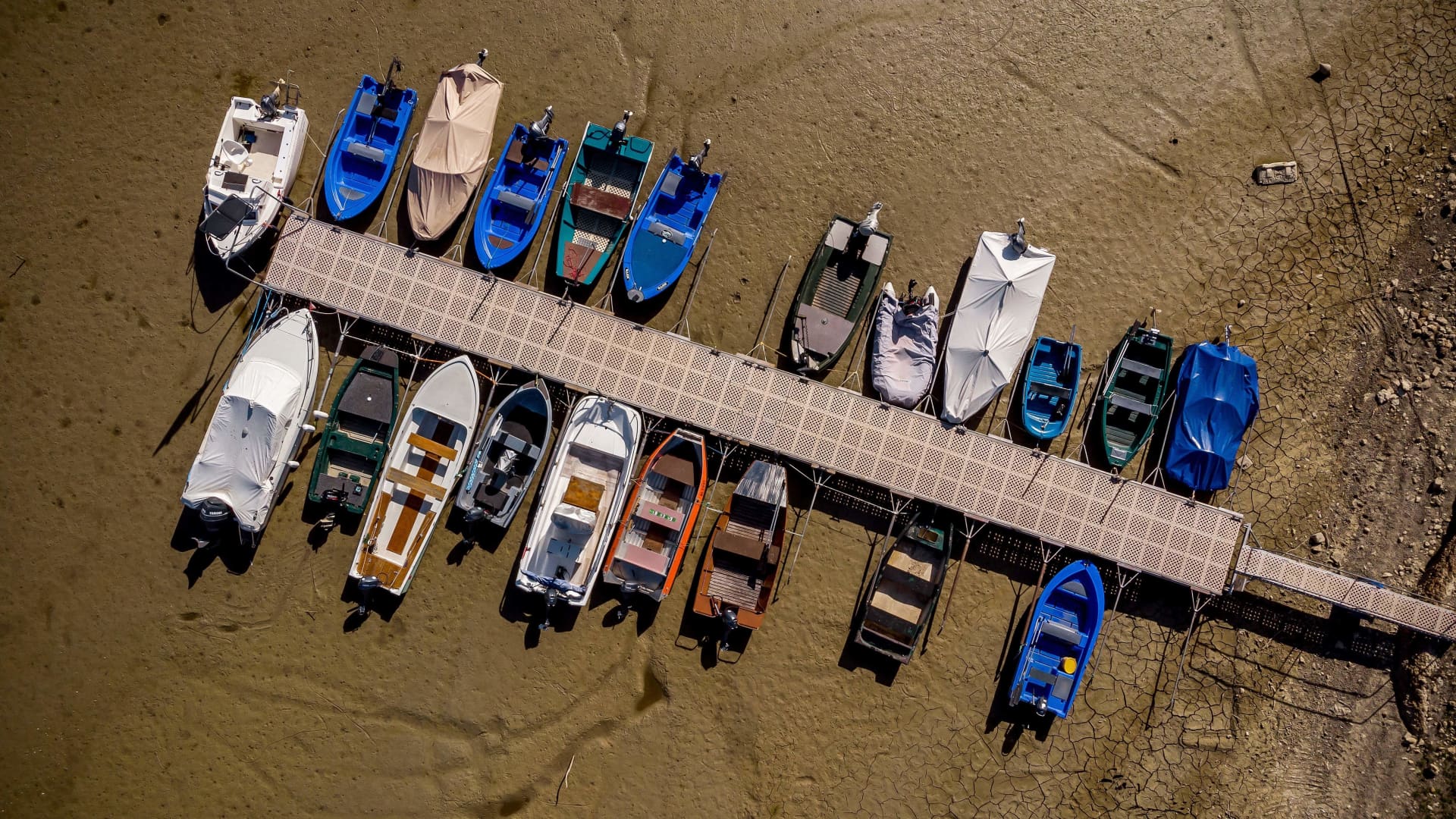 An aerial view shows boats in the dry bed of Brenets Lake (Lac des Brenets), part of the Doubs River, a natural border between eastern France and western Switzerland, in Les Brenets on July 18, 2022. 