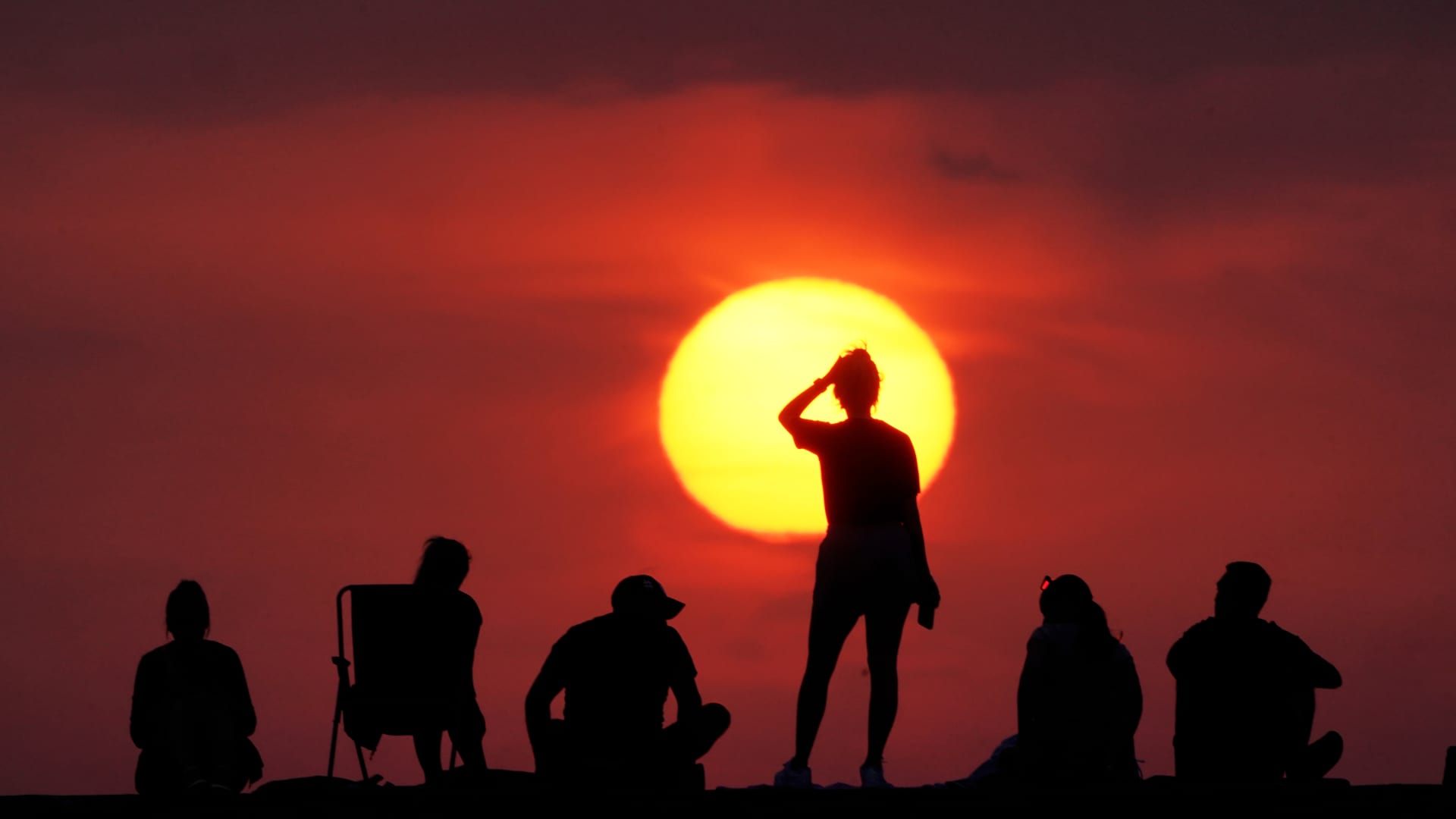 People turn out to watch the sunrise at Cullercoats Bay, North Tyneside. Britons are set to melt on the hottest UK day on record as temperatures are predicted to hit 40C. Picture date: Tuesday July 19, 2022.