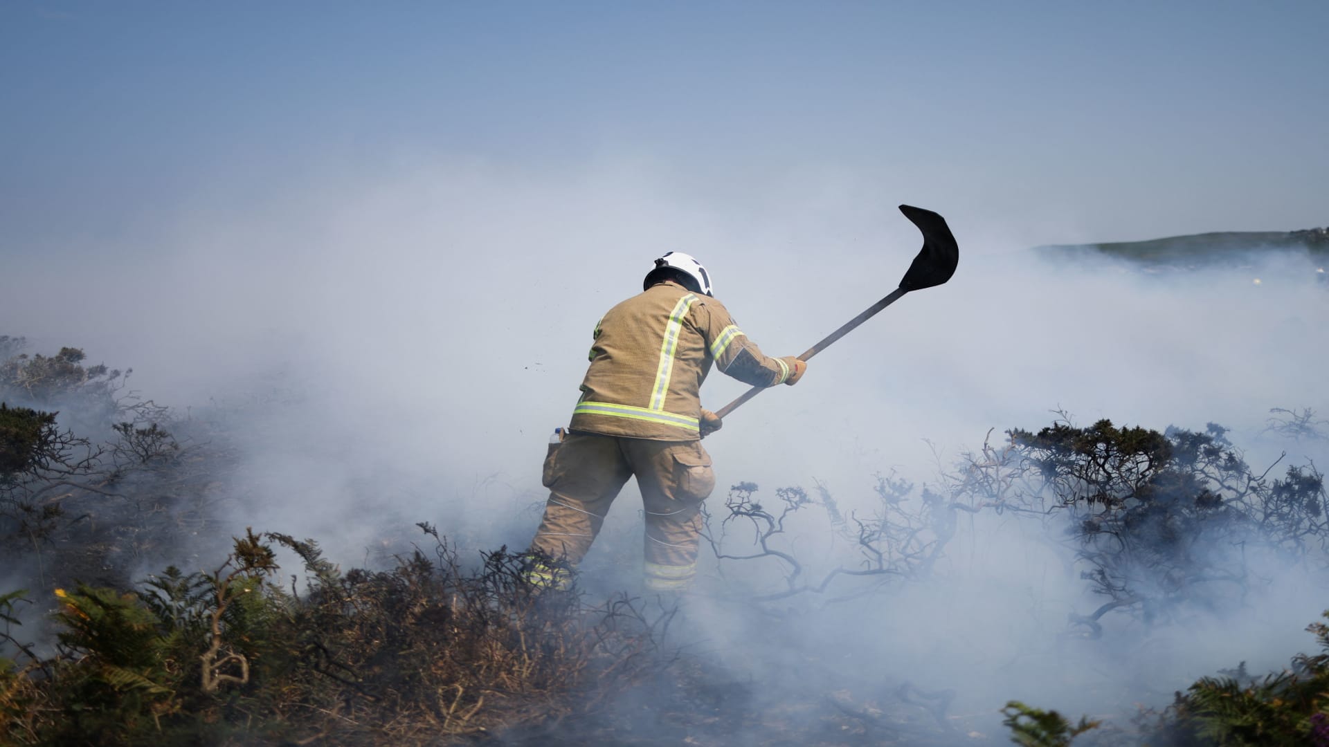 A firefighter attends a gorse bush fire, during a heatwave near Zennor, Cornwall, Britain, July 19, 2022. 
