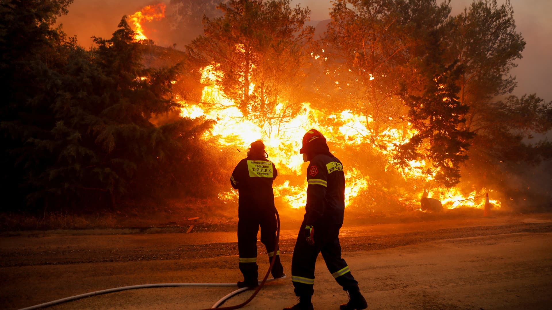 Firefighters try to extinguish a wildfire burning in Ntrafi, Athens, Greece, July 19, 2022.